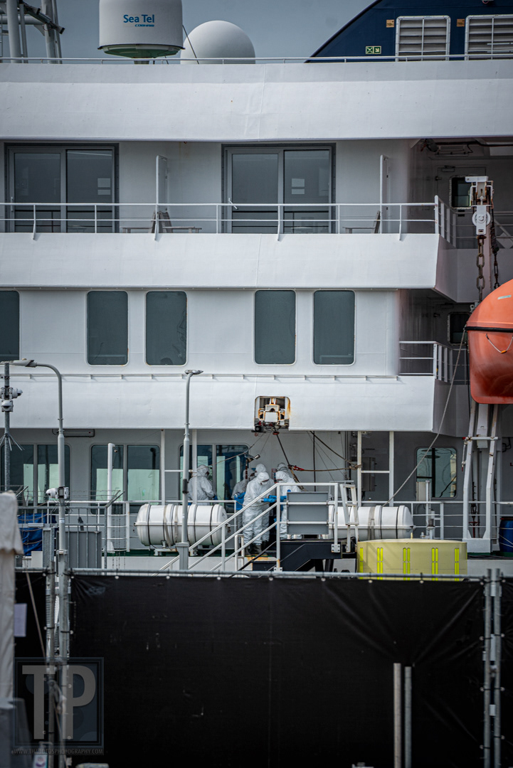 Leden van het ontsmettingsteam in overleg aan boord van de MV Hondius tijdens de ontsmettingsprocedure in de haven van Rotterdam, 19 mei 2026. · Members of the disinfection crew confer on board the MV Hondius during the disinfection procedure in the port of Rotterdam, 19 May 2026.