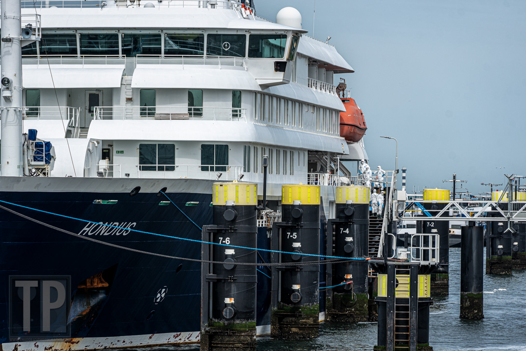 Leden van het ontsmettingsteam in overleg aan boord van de MV Hondius tijdens de ontsmettingsprocedure in de haven van Rotterdam, 19 mei 2026. · Members of the disinfection crew confer on board the MV Hondius during the disinfection procedure in the port of Rotterdam, 19 May 2026.