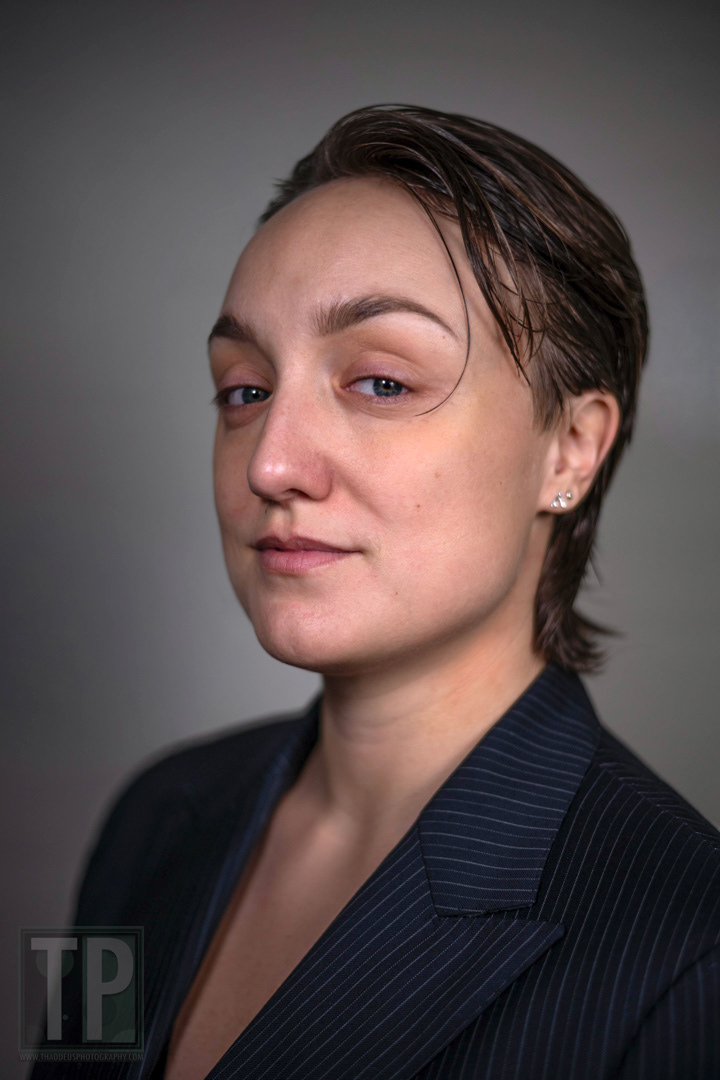 Claudia is sitting for a portrait session, preparing for both professional and lighthearted headshots.