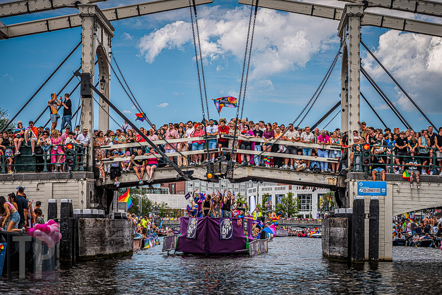 Toeschouwers verdringen zich op een brug over de Amsterdamse grachten tijdens de Canal Parade van WorldPride Amsterdam 2026, Amsterdam, 1 augustus 2026. · Spectators crowd a bridge over the Amsterdam canals during the Canal Parade at WorldPride Amsterdam 2026, Amsterdam, 1 August 2026.