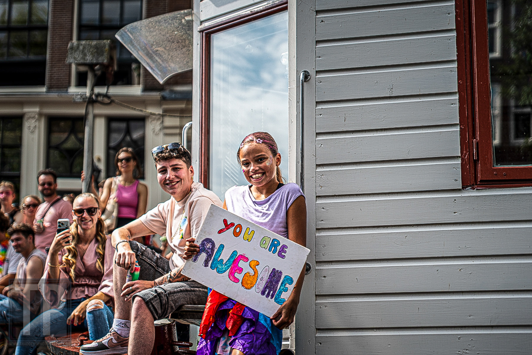 Een deelnemer houdt een bord met "You Are Awesome" omhoog tijdens de Canal Parade van WorldPride Amsterdam 2026, Amsterdam, 1 augustus 2026. · A participant holds a "You Are Awesome" sign during the Canal Parade at WorldPride Amsterdam 2026, Amsterdam, 1 August 2026.
