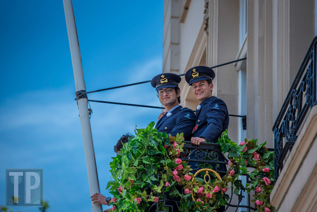 Military cadets watch from a balcony as a military parade passes the Koninklijke Schouwburg (Royal Theater).