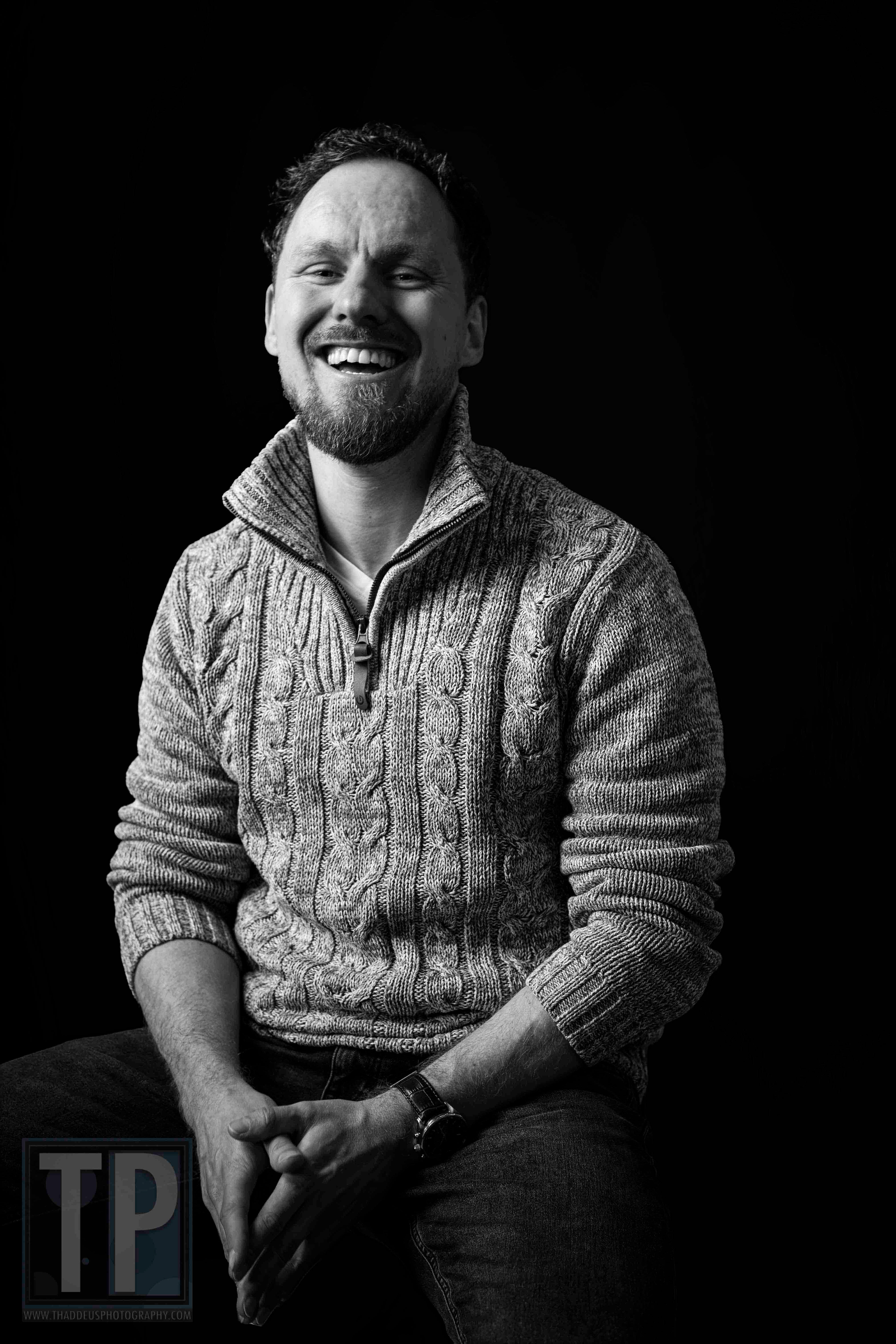 Tim, zwart-witportret met een natuurlijke, ontspannen lach tijdens een portretsessie, 14 april 2026. · Tim, black-and-white portrait with a natural, relaxed laugh during a portrait session, 14 April 2026.