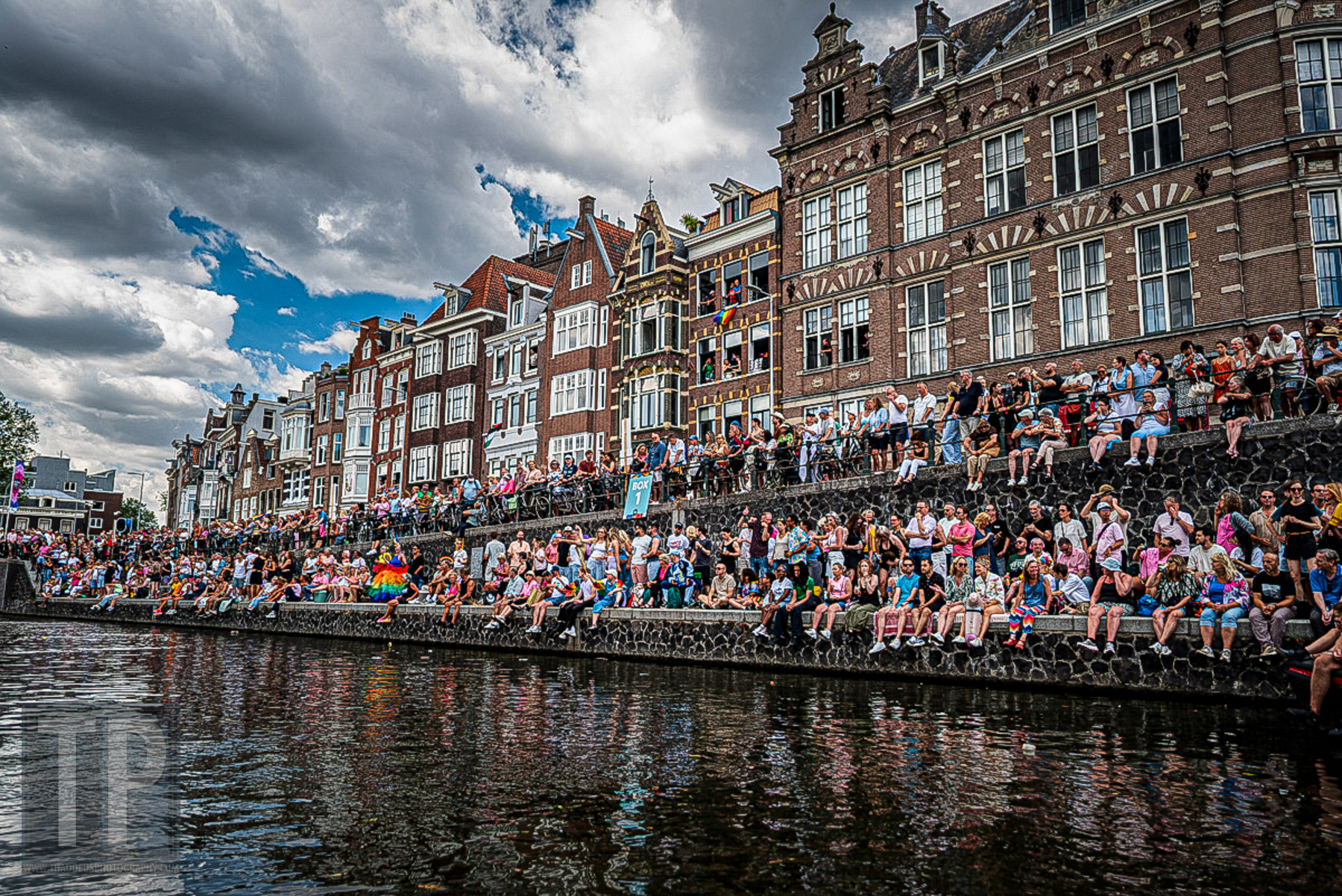 Toeschouwers langs de Amsterdamse grachten verwelkomen de deelnemers aan de Canal Parade van WorldPride Amsterdam 2026, Amsterdam, 1 augustus 2026. · Spectators line the Amsterdam canals, welcoming participants in the Canal Parade at WorldPride Amsterdam 2026, Amsterdam, 1 August 2026.