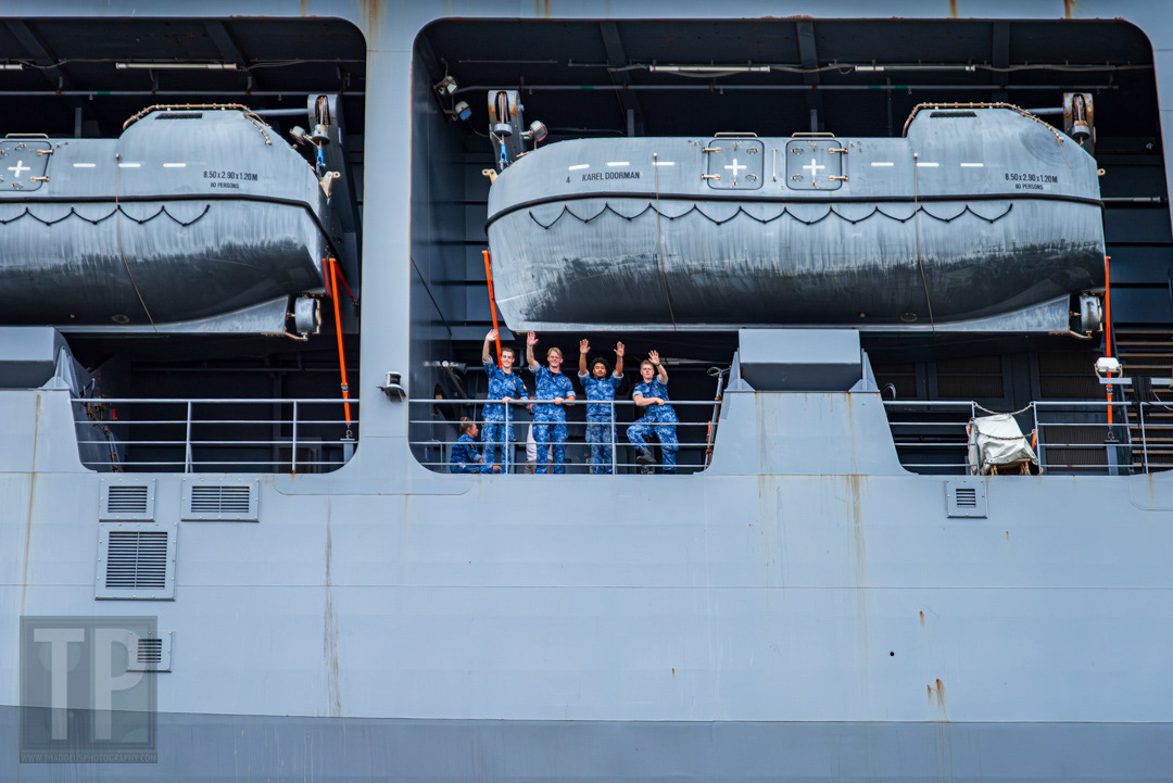 Dutch Navy sailors wave towards passing ships during Amsterdam SAIL 2025.
