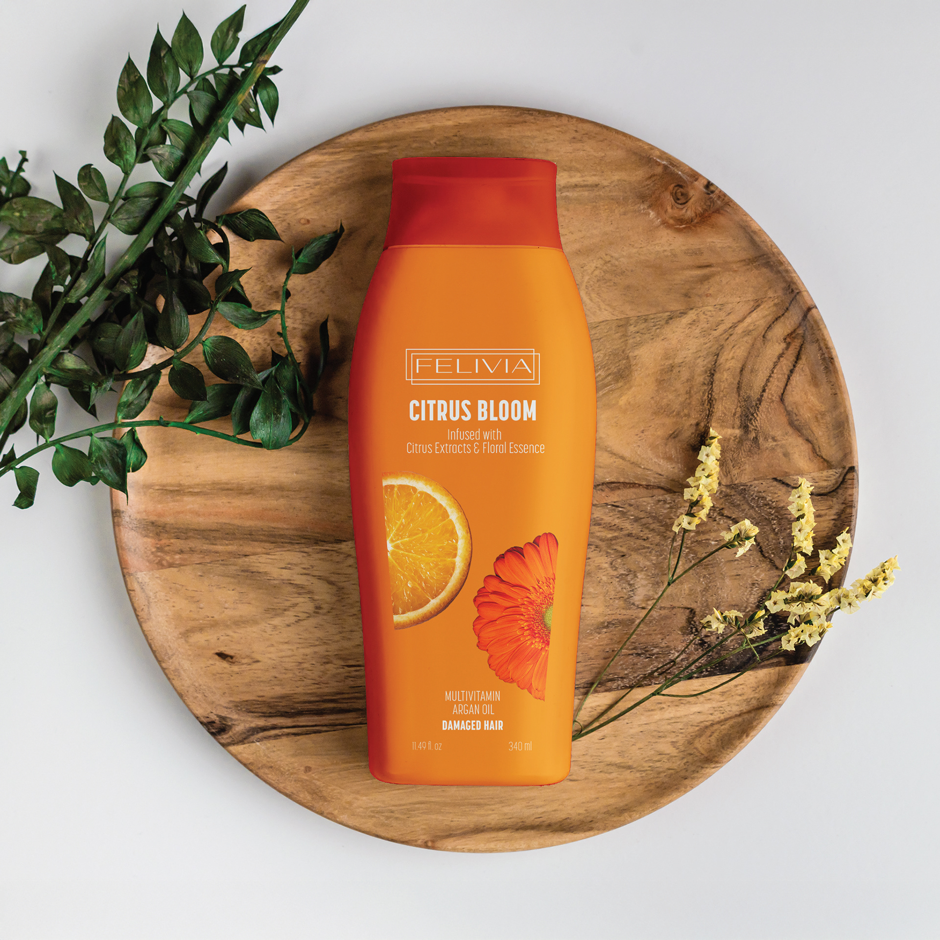 A vibrant and refreshing shampoo bottle design for Felivia's Citrus Bloom collection, featuring botanical illustrations and warm orange tones.
