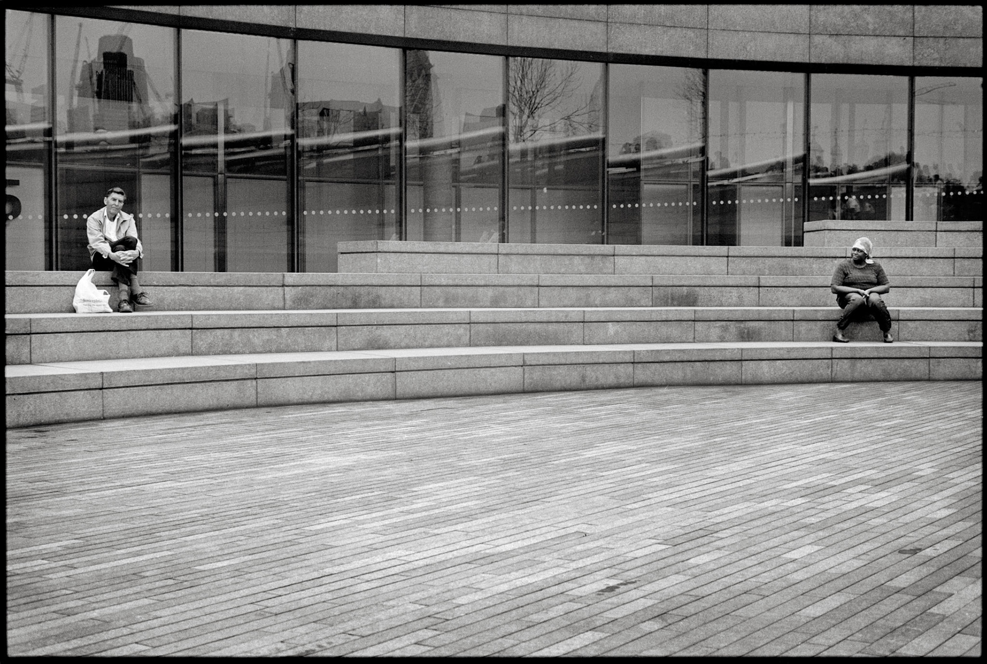 Near London City Hall there is this little agora where it is nice and easy to sit talk, have a lunch or whatever. Those two people look isolated, worlds apart from each other. And then she turns her head, maybe she looks at him, maybe not. Probably not. Who knows?
