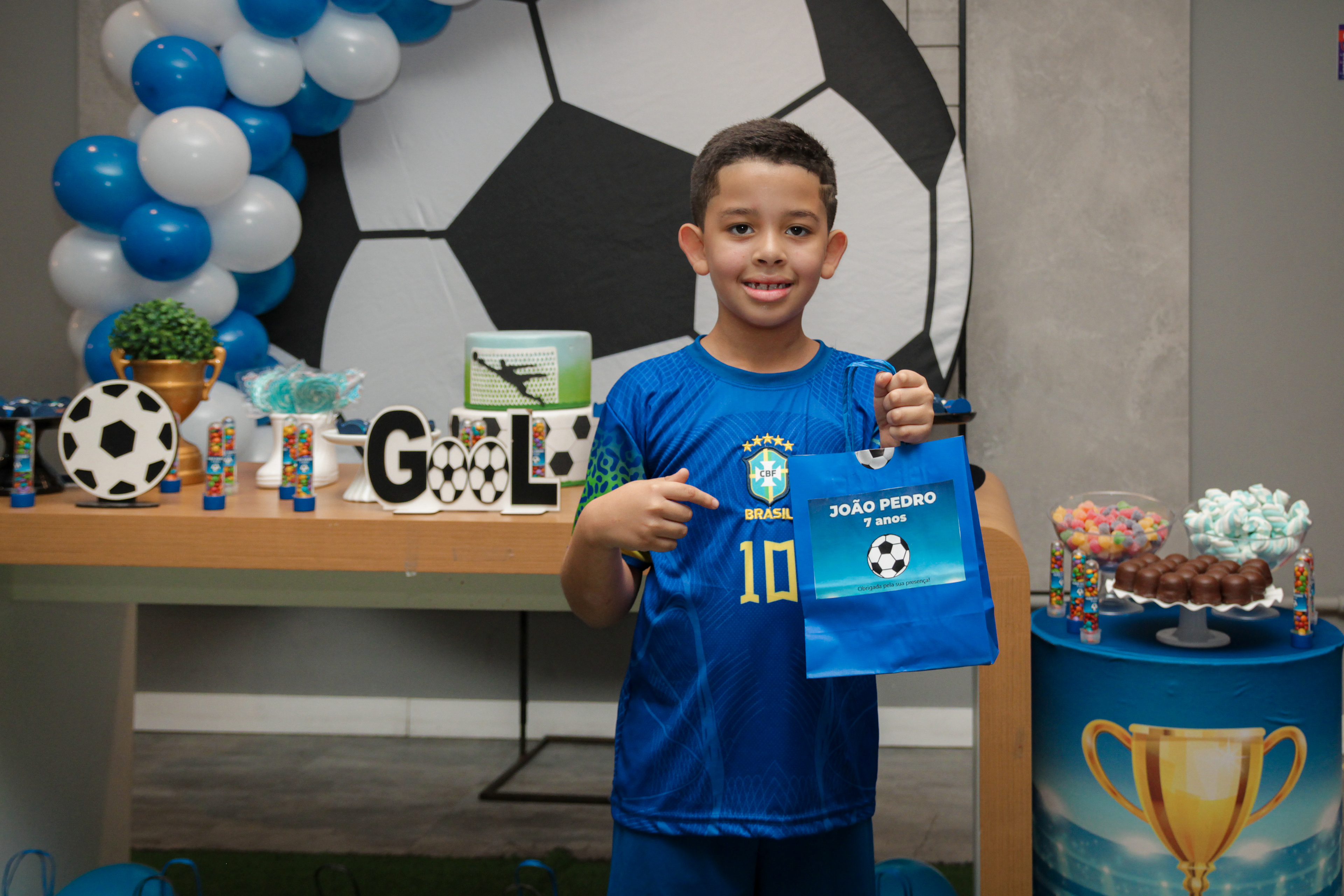 oão Pedro em pose alegre, aniversário infantil.