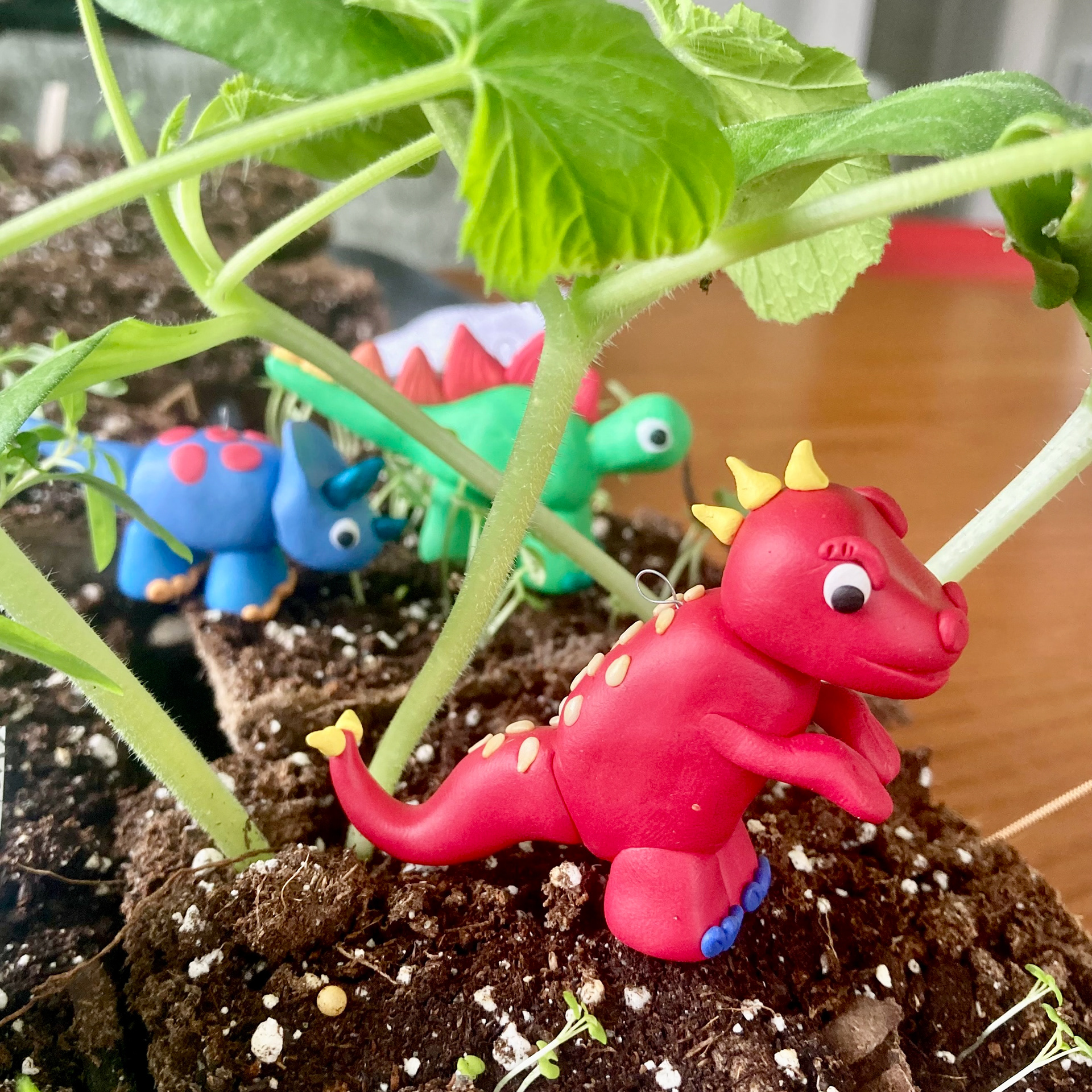 Dinos wandering through a forest of zucchini seedlings
