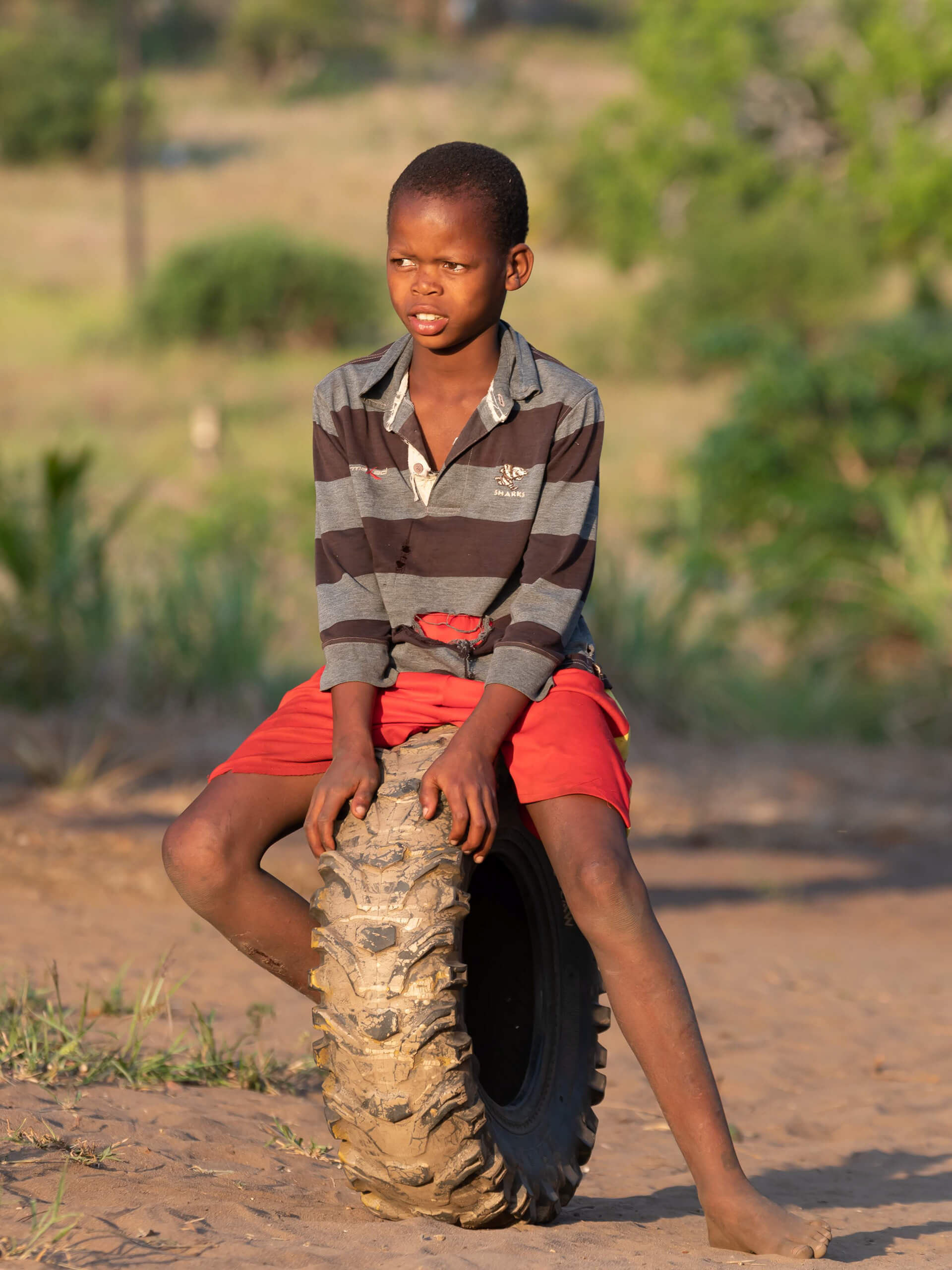 Young boy sitting on a truck tire at Lago Matsambe, Mozambique