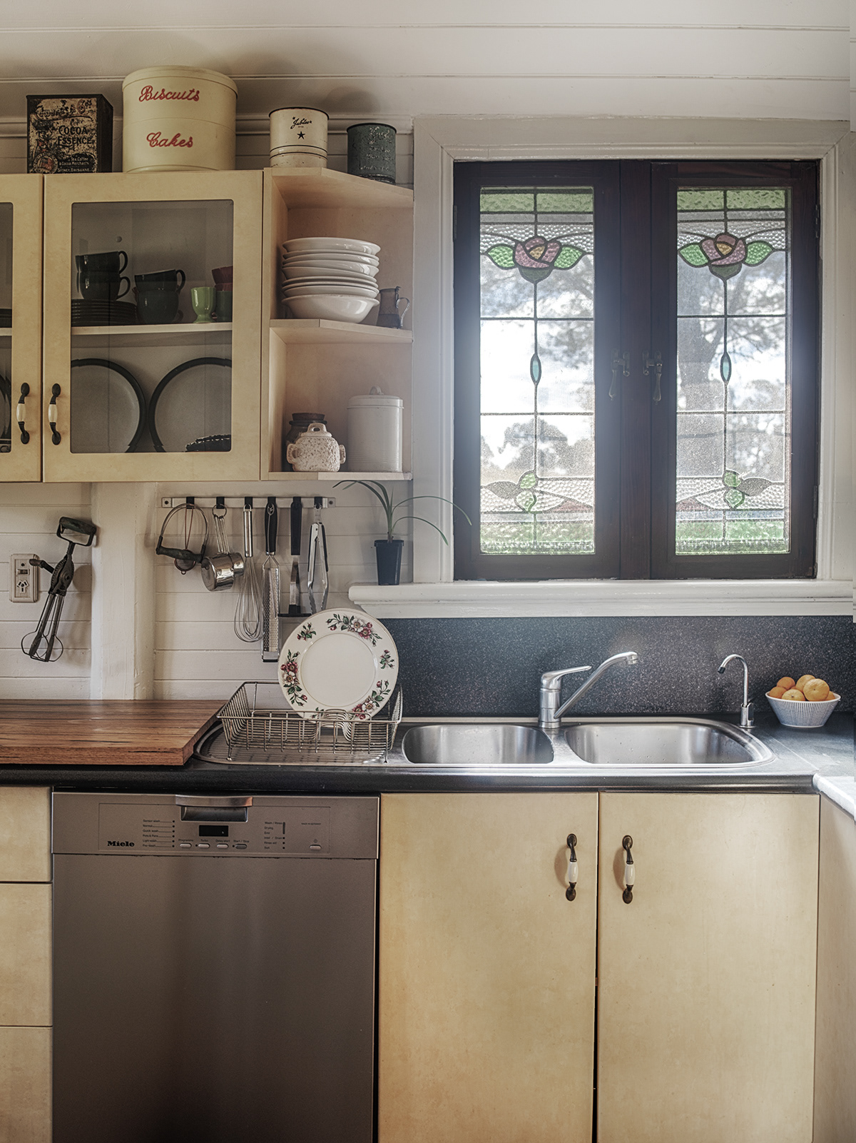 Another view of the kitchen including the kitchen sink with leadlight windows and panelled cove ceiling