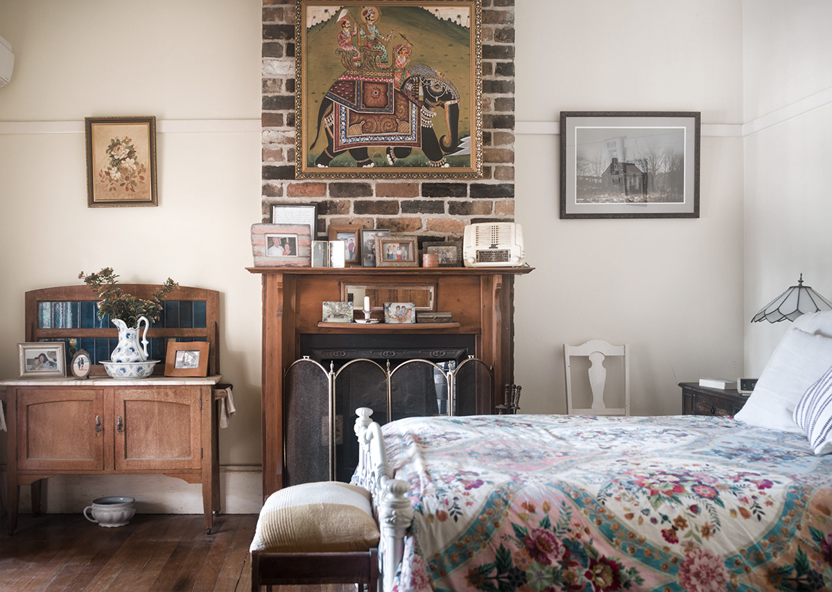 A part of the main bedroom. The fireplace mantle was painted white at some stage so it was stripped back to reveal the original Kauri pine timber. Viburnum in jug from the garden