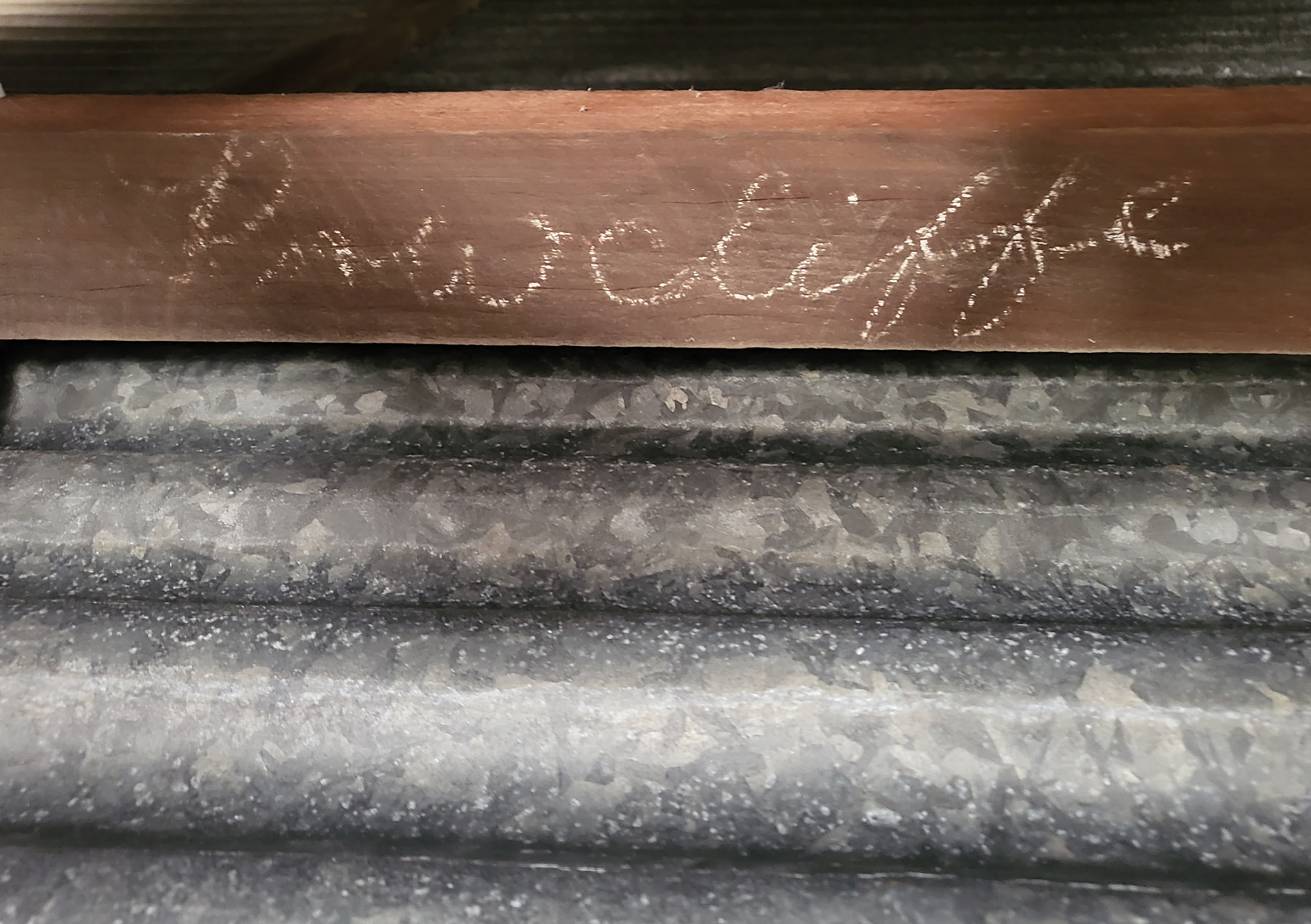 Name of the original owners in chalk survives over a hundred years on a beam in the barn