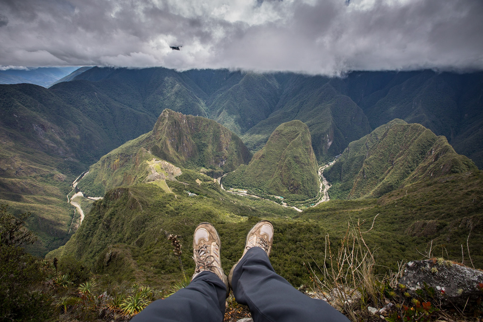 Machu Picchu, Peru, stands 2,430 m above sea-level, in the middle of a tropical mountain forest, in an extraordinarily beautiful setting. I stayed in the site for a full day: from 06:00 (just before sunrise), enjoying and picturing an amazing mixture of light and fog, until 17:00 (closing time) when you almost have the ruins to yoursel.Many visitors climb Huayna Picchu mountain, as I did many years ago. It is the one that appears behind the Inca City in the classic postcard photo of Machu Picchu. It can be scary for people with fear of heights.This is a view from the top of Machu Picchu Mountain, which offers less steep but higher, wider and visually less frightening roads than Huayna Picchu.