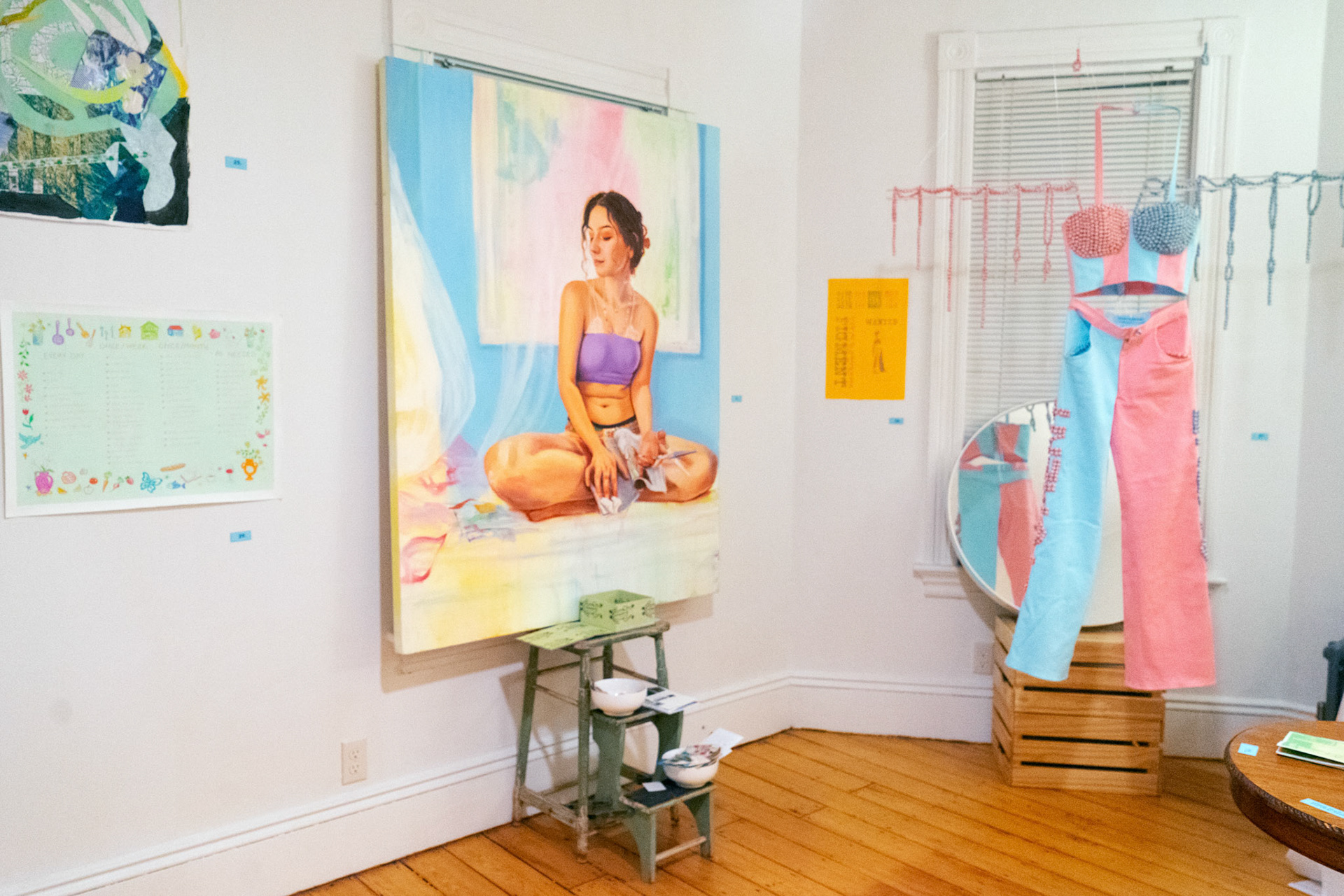 left to right: "untitled (chore chart)" and "at home with here" by Hannah Bashkow (paintings), "frog box" by Ivana Primero, "Wanted: Two-Color Figment" (letterpress) and "Two (P/F)igments" (performative apparel) by Iris Wright (this photo by Jaden Bleier)