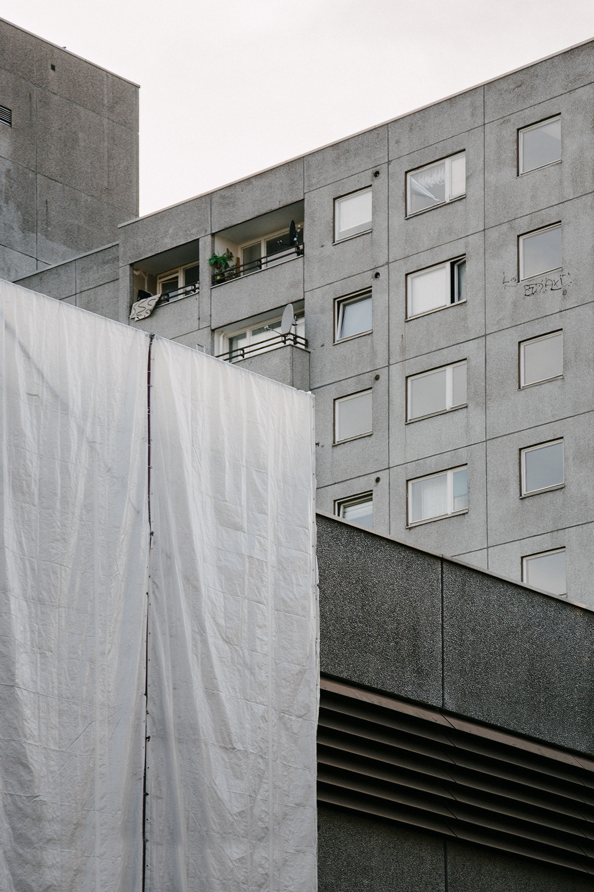 Fassadenansicht von Mehrfamilienhaus mit Bauplane im Vordergrund in Ritterstrasse, Berlin-Kreuzberg.