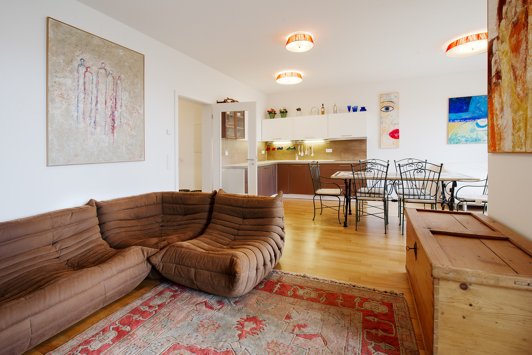 Immobilienfotografie zeigt Wohnzimmer im Vordergrund und Küche im Hintergrund