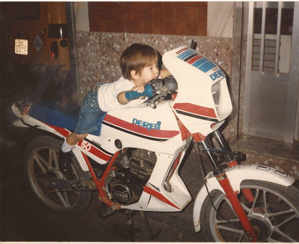 Childhood photo of Jose beside a motorcycle