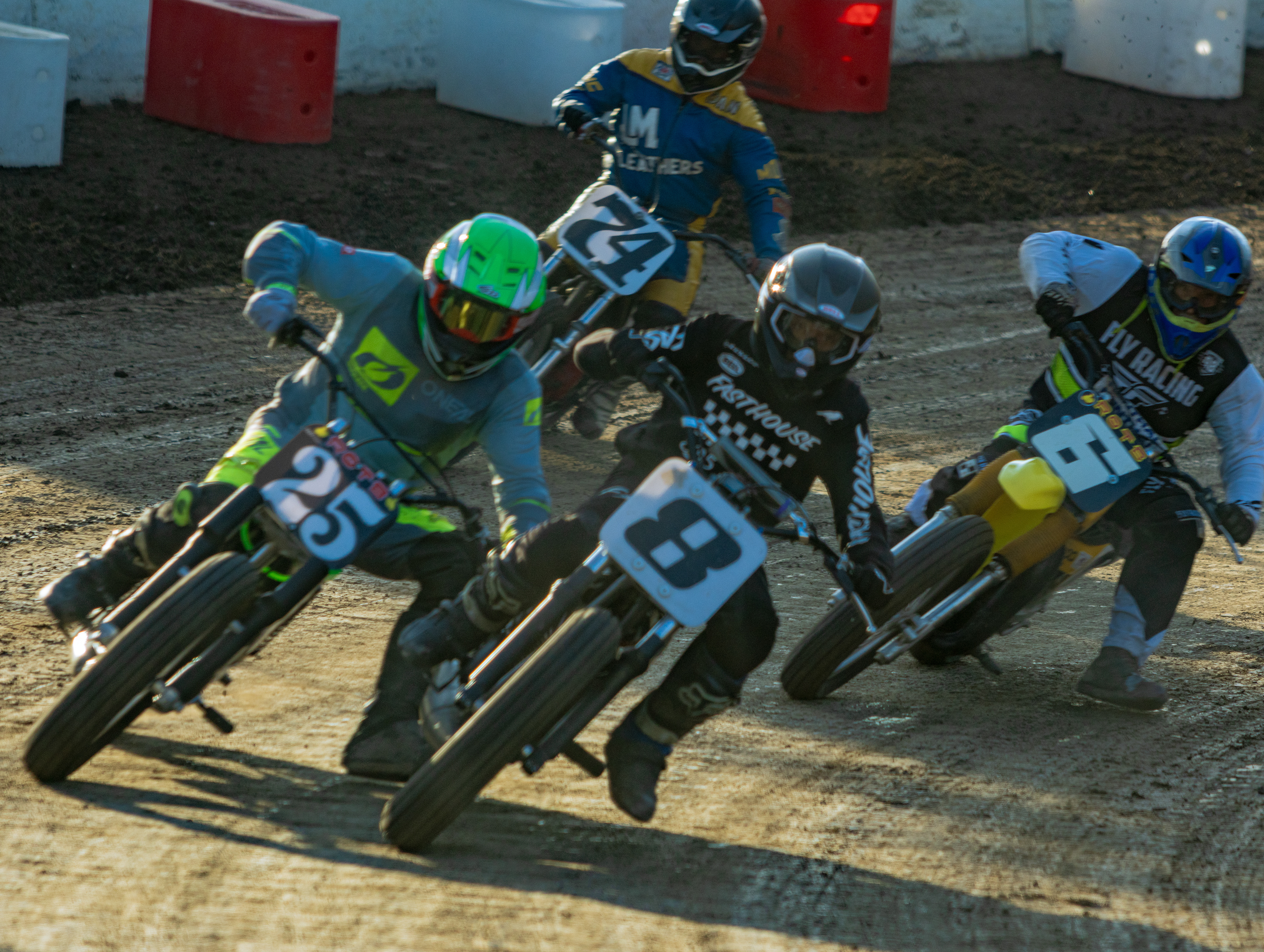 Flat track riders racing together on a dirt oval
