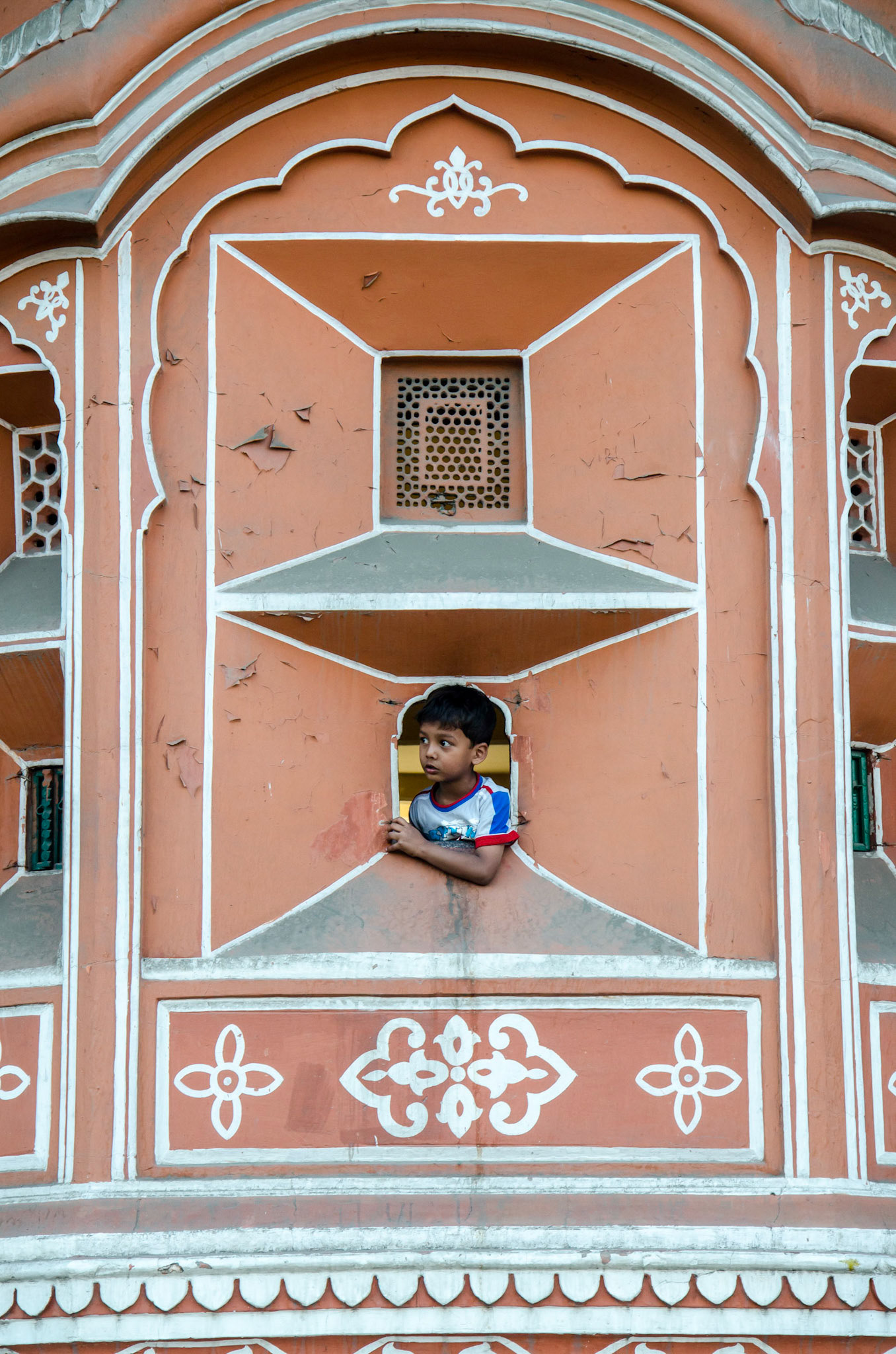 A boy peeping out of a window in Hawa Mahal