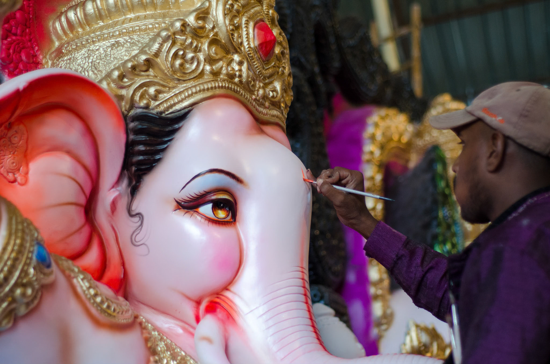 A sculptor making a finishing touch on a Ganesha idol