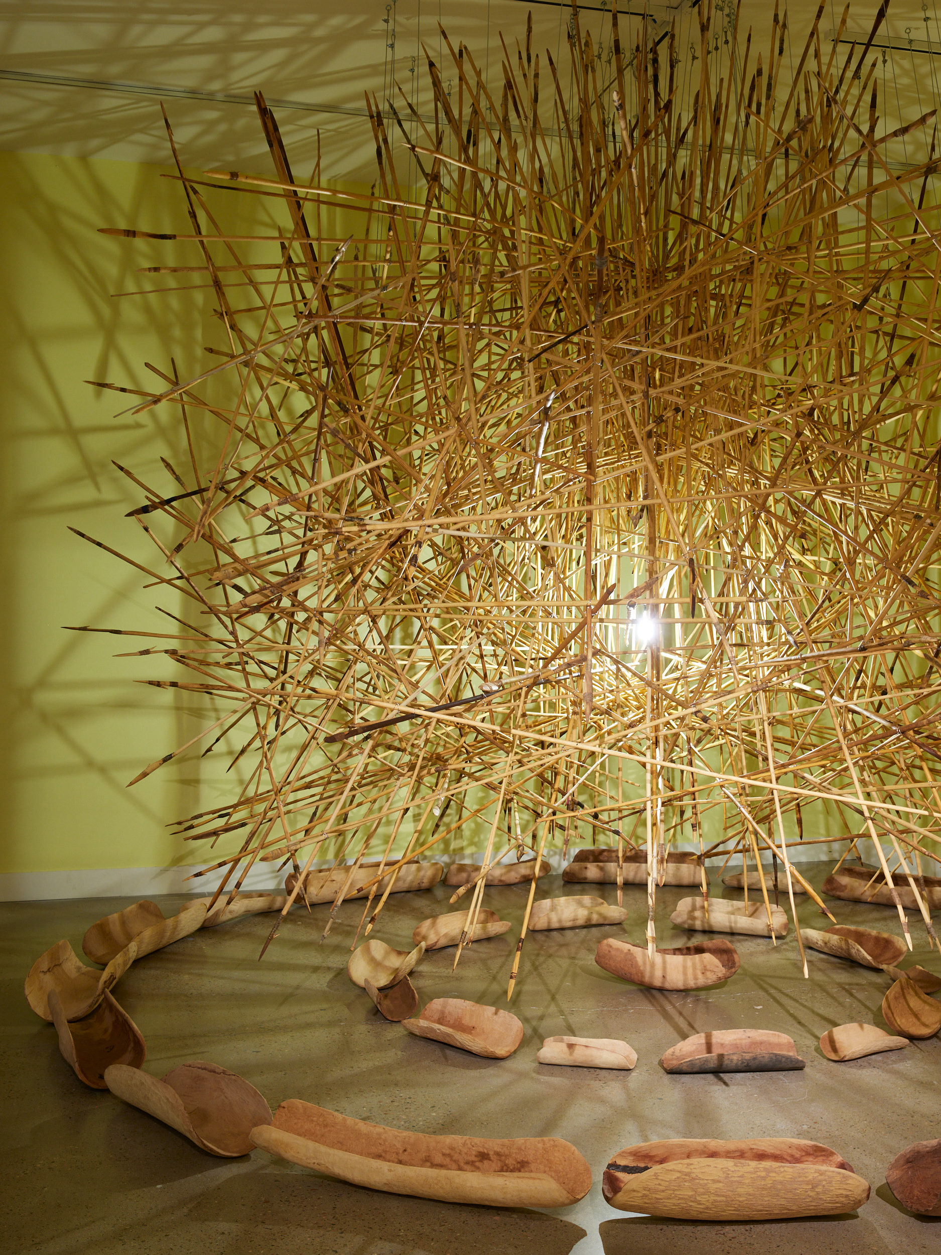 APY Art Collective. KULATA TJUTA, 2017. 550 suspended kulata (spears), 27 coolamons (wooden bowls), dimensions vary. Circumference work itself: 6-7M diameter. Image by Brad Trone