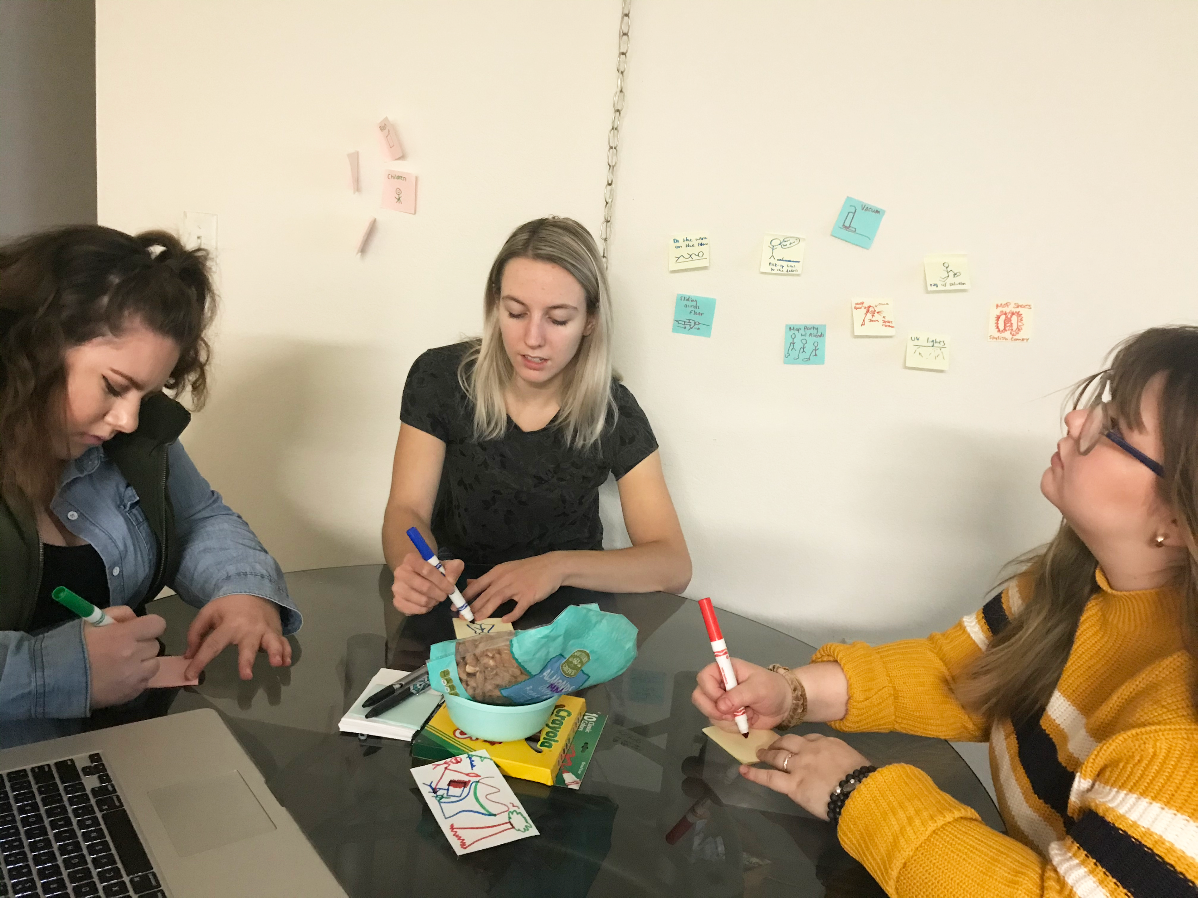 Three people writing on post-its
