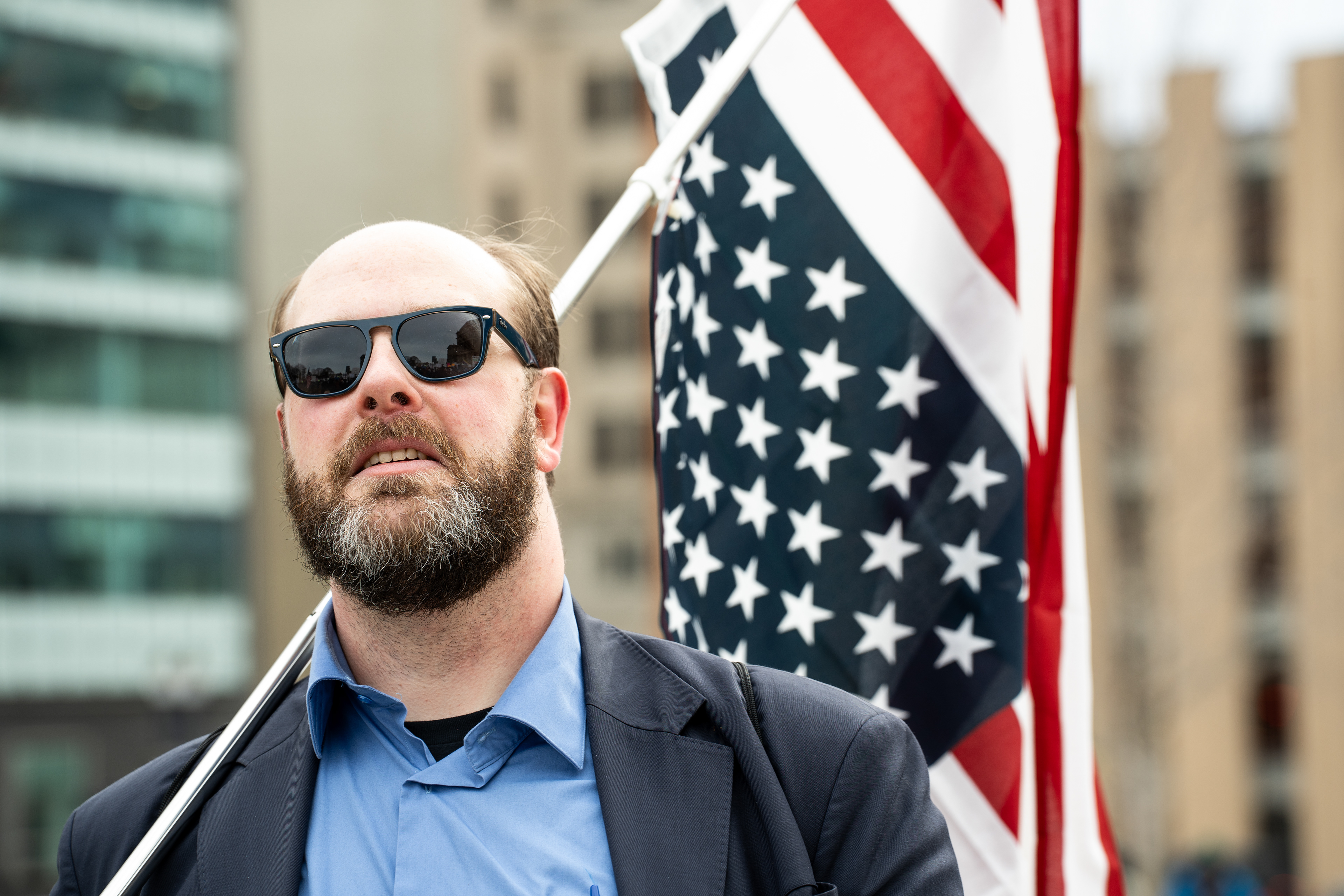 A protester carries an inverted United States flag at the Michigan Capitol Building in Lansing, Michigan on Feb. 5, 2025. Protesters gathered at the Michigan Capitol Building to demonstrate against President Donald Trump's cascade of executive orders.