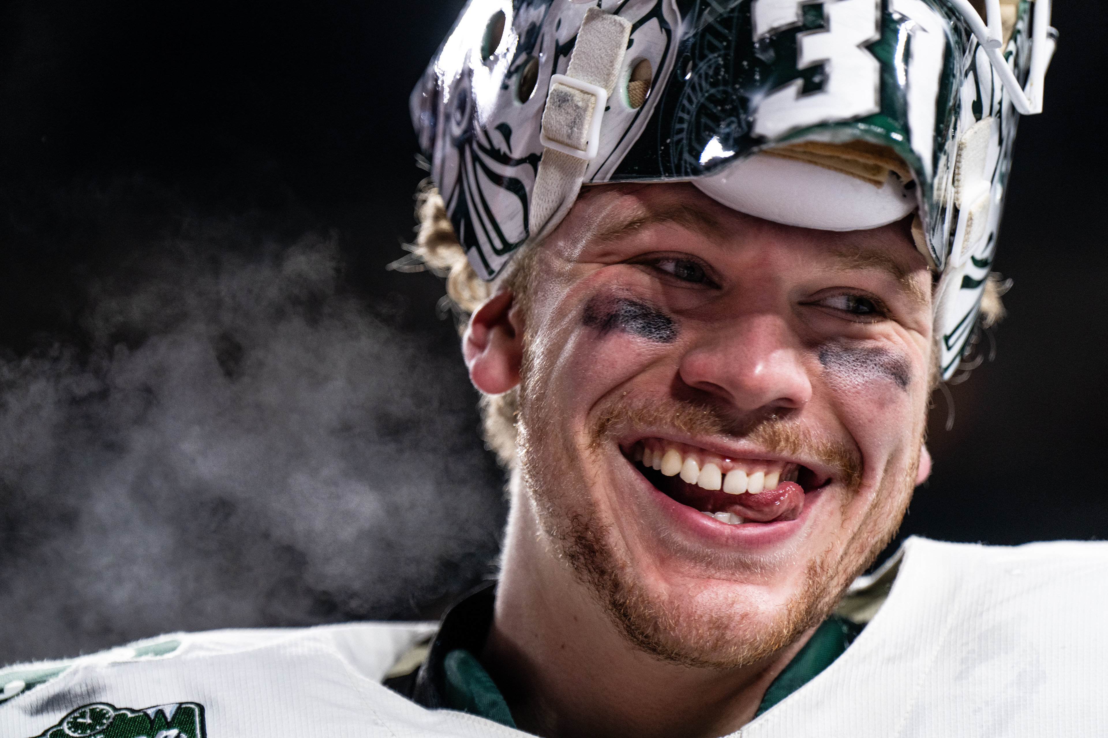 Michigan State sophomore goaltender Luca Di Pasquo (31) smiles following an overtime victory over the University of Wisconsin at Wrigley Field in Chicago on Jan. 4, 2025. The Spartans' junior forward Daniel Russell (20) netted the overtime winner with under two seconds remaining, earning the weekend sweep over the Badgers.