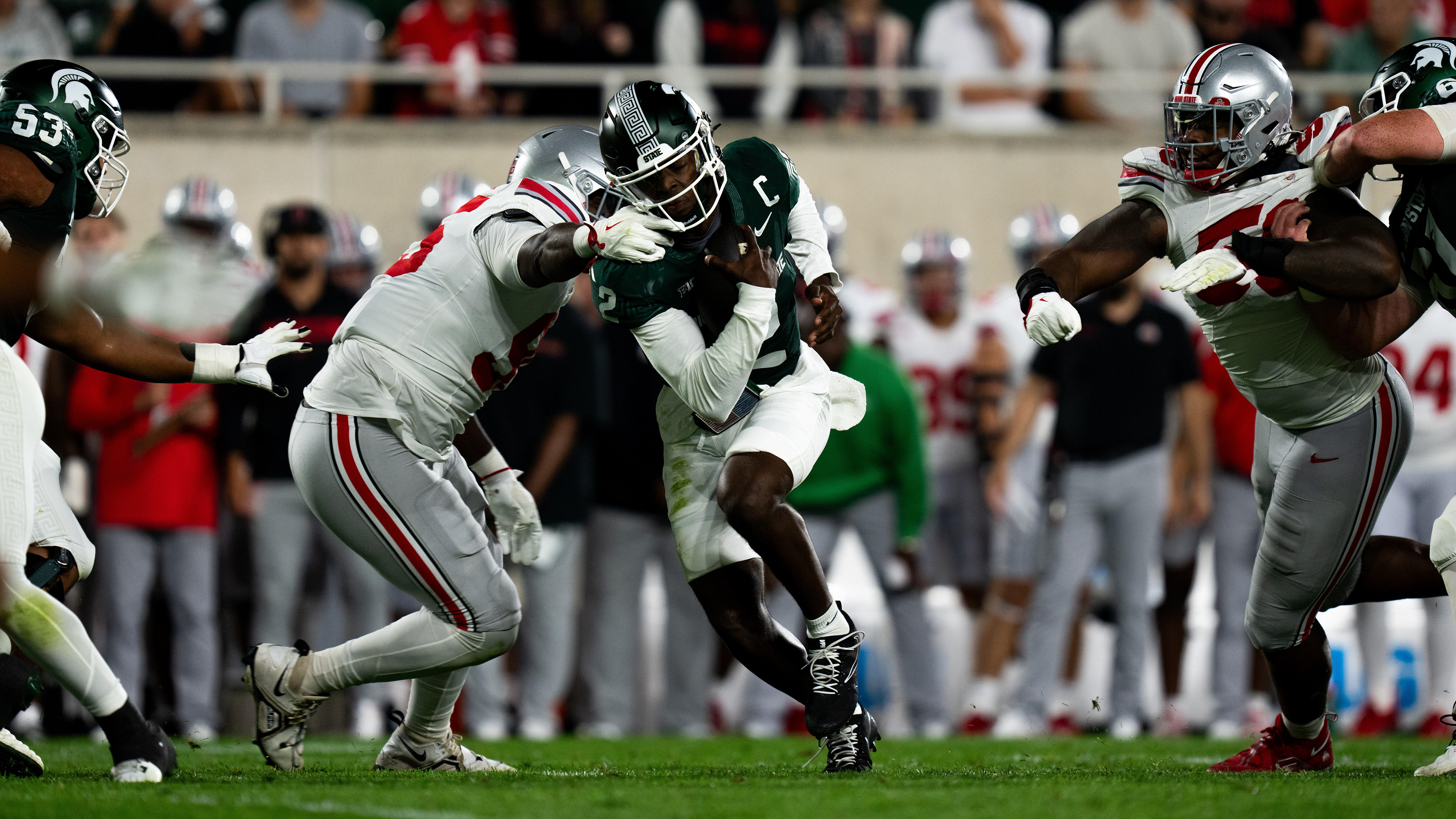 Michigan State sophomore quarterback Aiden Chiles (2) takes a facemask grab from the Ohio State defender during a football game at Spartan Stadium on Sept. 28, 2024. Despite a competitive first half, the Spartans fell 38-7 to the Buckeyes.