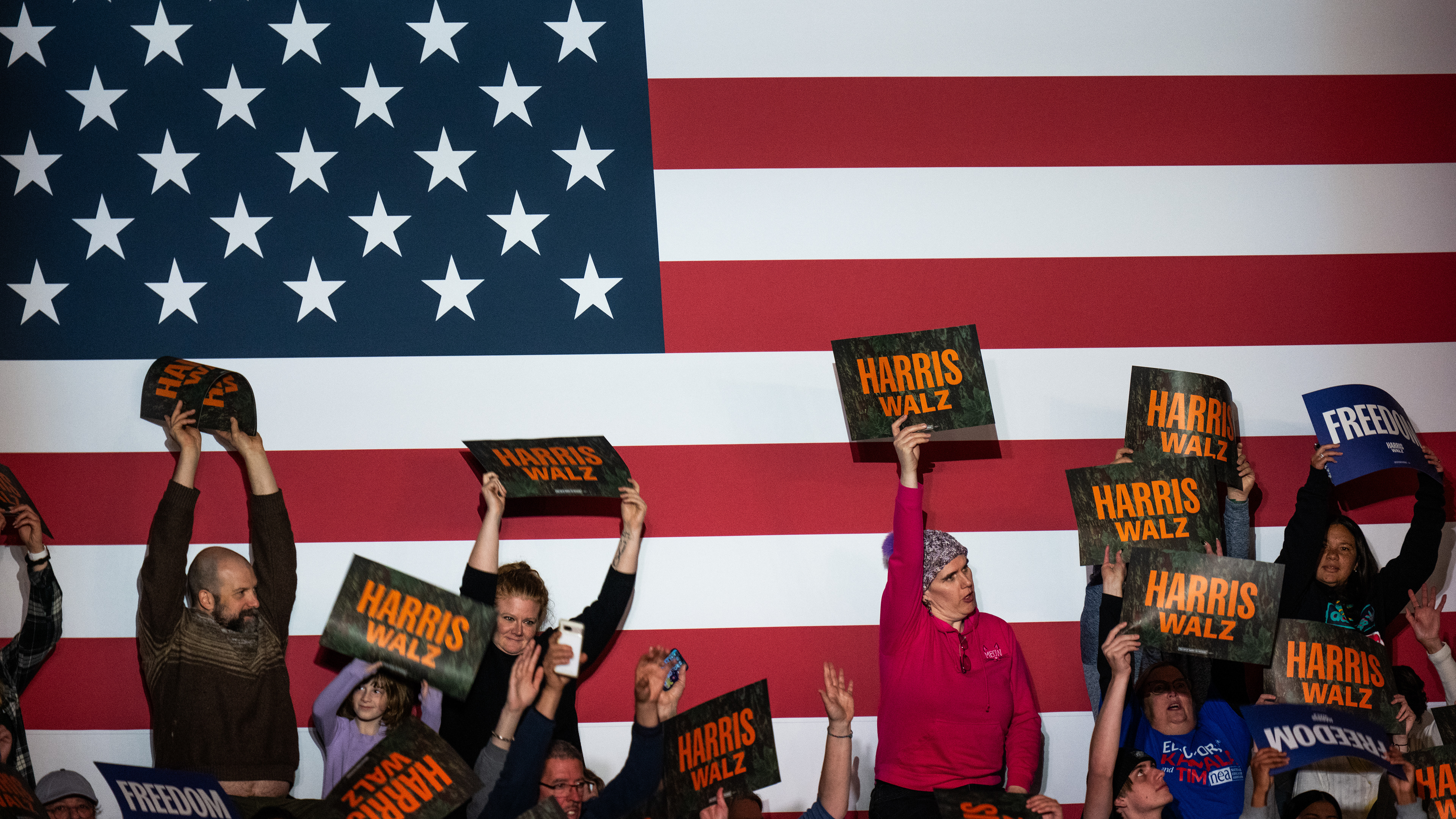 Members of the crowd hold campaign signs at Vice President Kamala Harris' presidential campaign rally on Michigan State University's campus in East Lansing, Michigan on Nov. 3, 2024. Vice President Harris' rally at MSU demonstrates this election cycle's focus on young voters and battleground states like Michigan.