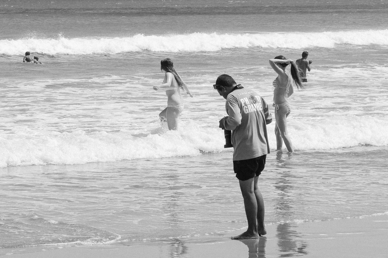 Beach photographer taking picture of clients during surf class. Kuta, 2014. 