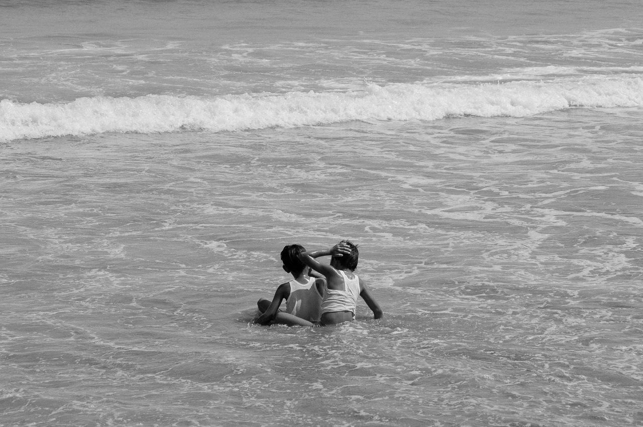 Two kids accidentally bump their head to each other while playing on the shallow. Kuta, 2014.