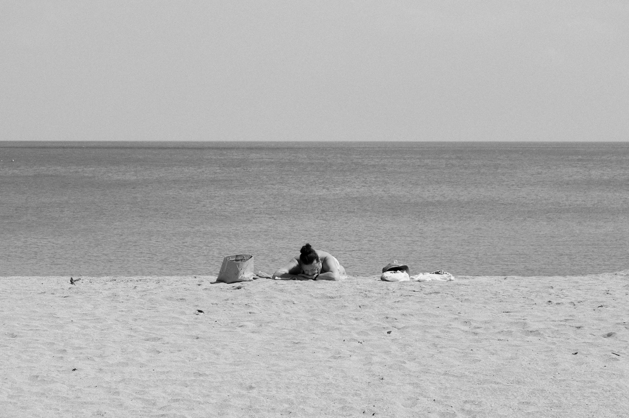 Woman sunbathing by herself. Kuta, 2014.