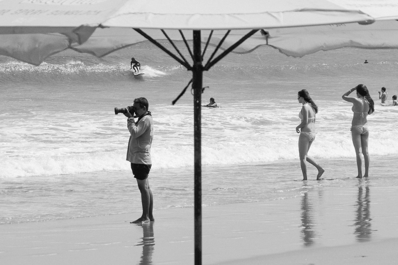 Beach photographer taking picture of clients during surf class. Kuta, 2014. 