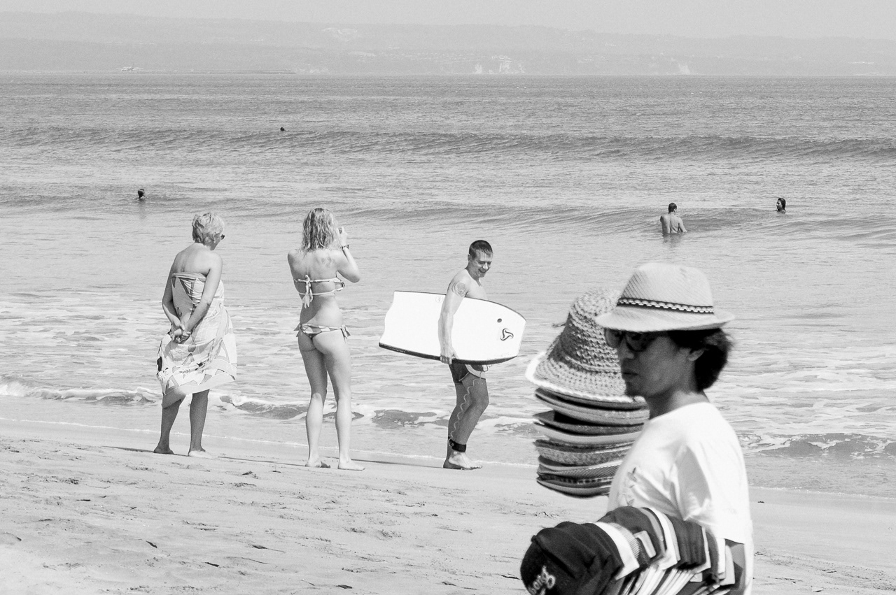 Tourists and straw hats seller. Kuta, 2014.