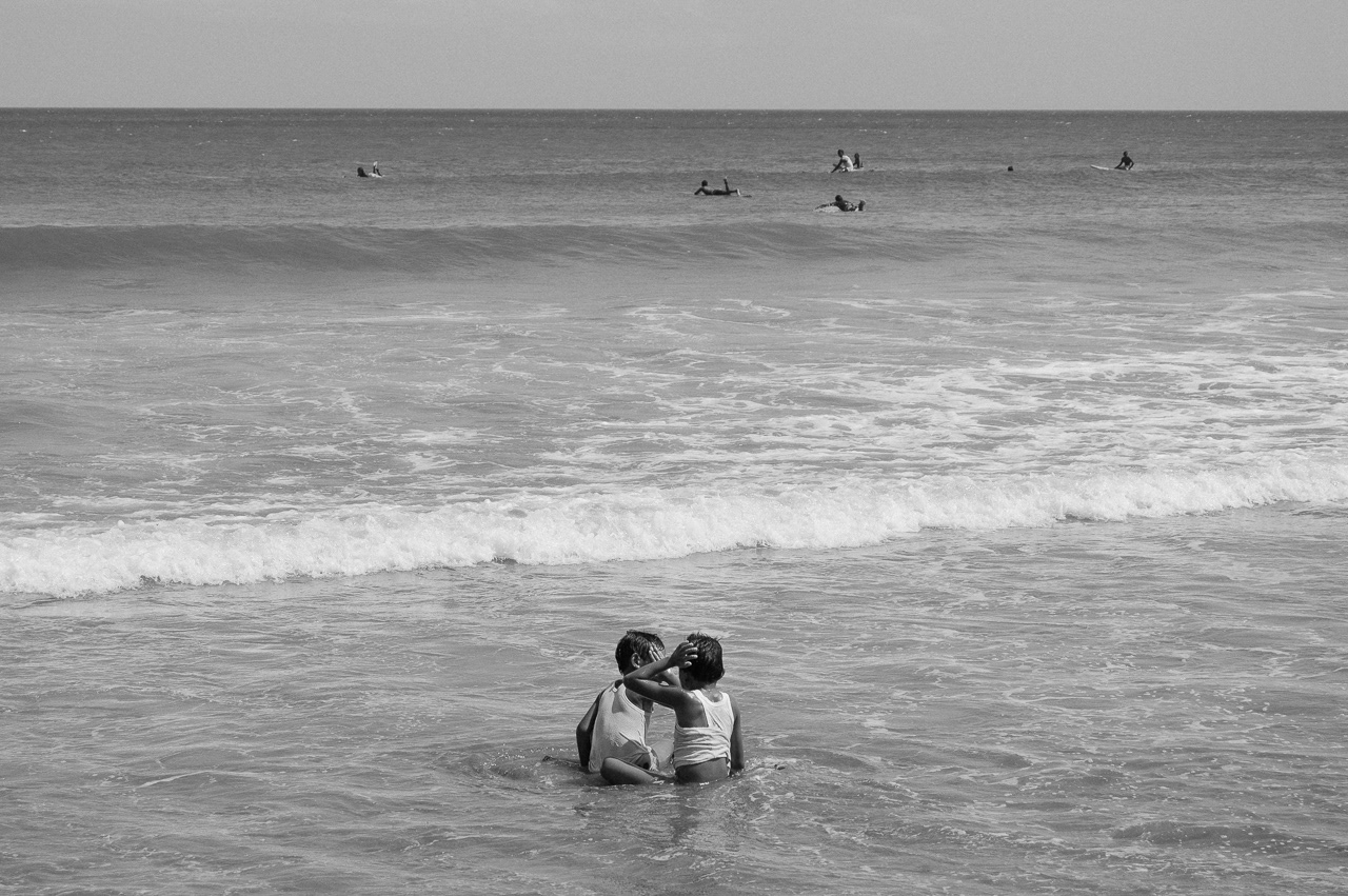 Two kids accidentally bump their head to each other while playing on the shallow. Kuta, 2014.