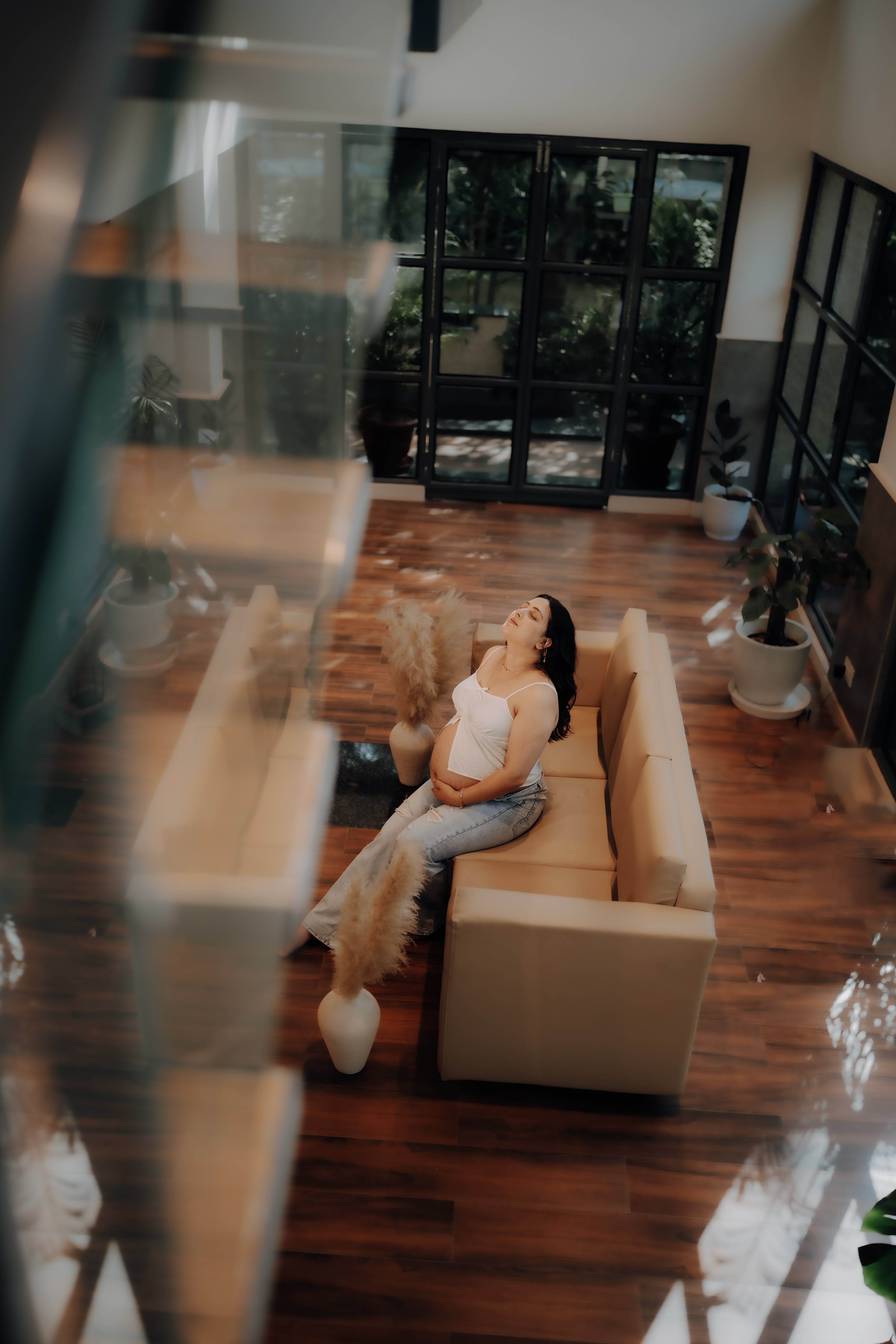 A mother’s calm before the storm — captured in elegance on a dreamy indoor sofa setup at Aqua Vista."