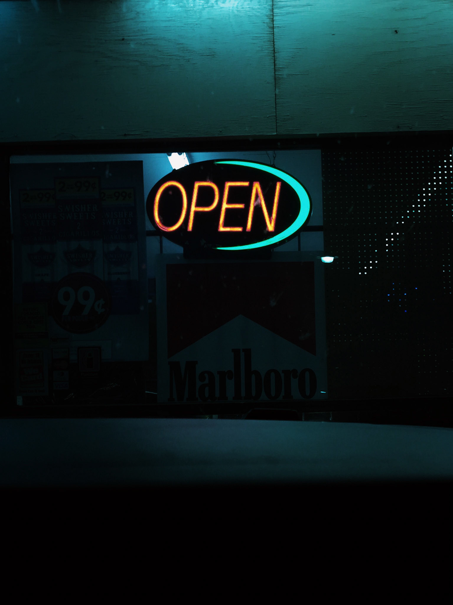 a neon open sign captured at night with blue light emitting