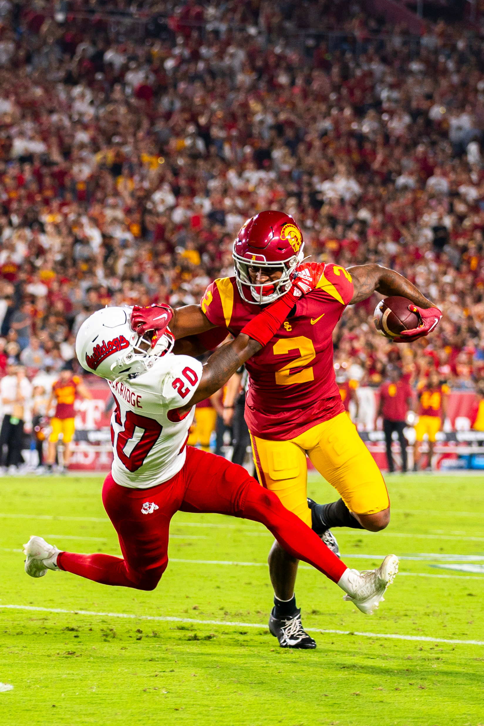 USC wide receiver Brenden Rice (2) holds off Fresno State defensive back Cam Lockridge (20) by the face mask in the first half of the NCAA college football game at Los Angeles Memorial Coliseum in Los Angeles, California, on September 17, 2022. (Vincent Leo/Daily Trojan)