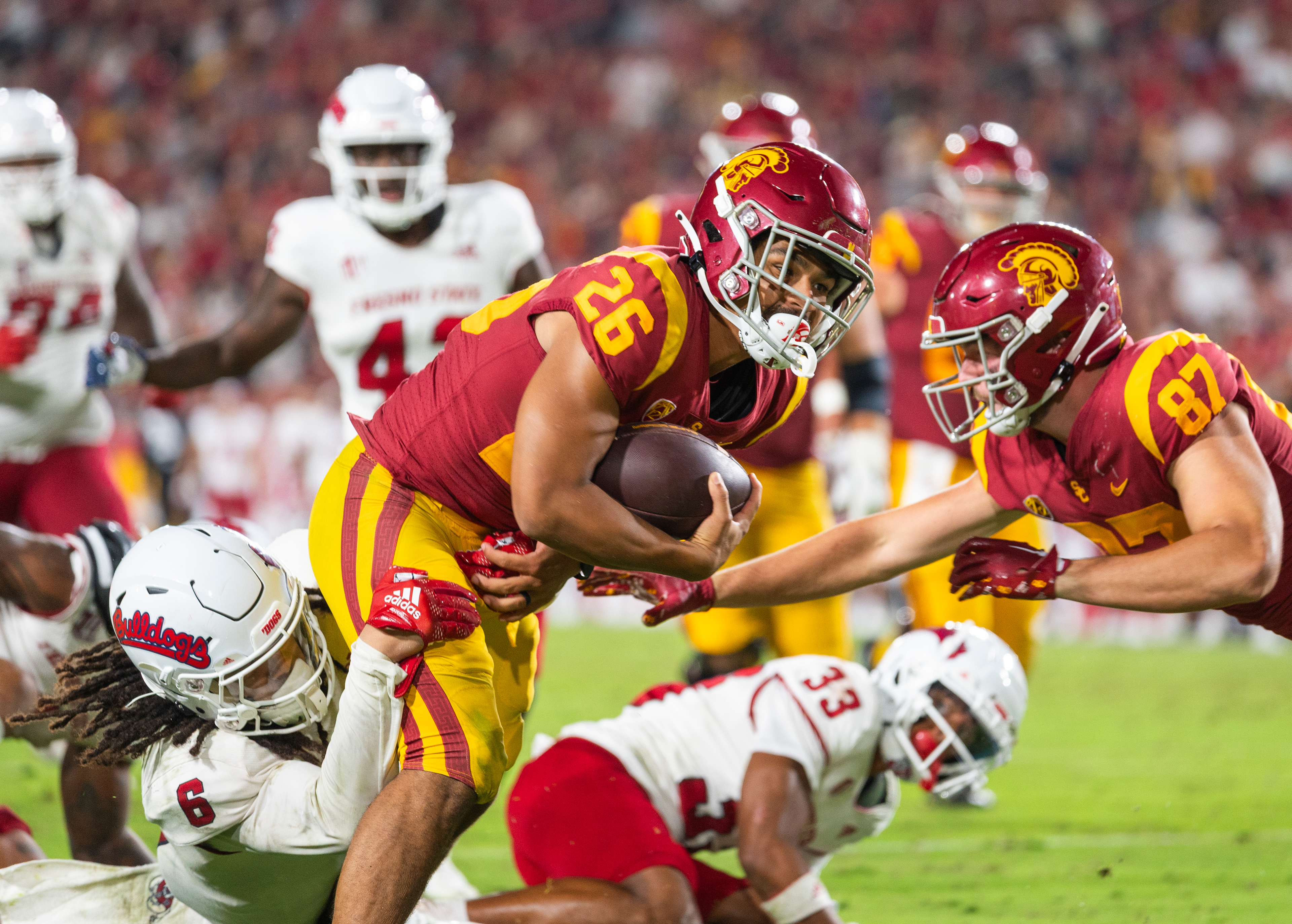 USC running back Travis Dye (26) holds onto the football while Fresno State linebacker Levelle Bailey (6) attempts to pull him down in the second half of the NCAA college football game at Los Angeles Memorial Coliseum in Los Angeles, California, on September 17, 2022. (Vincent Leo/Daily Trojan)