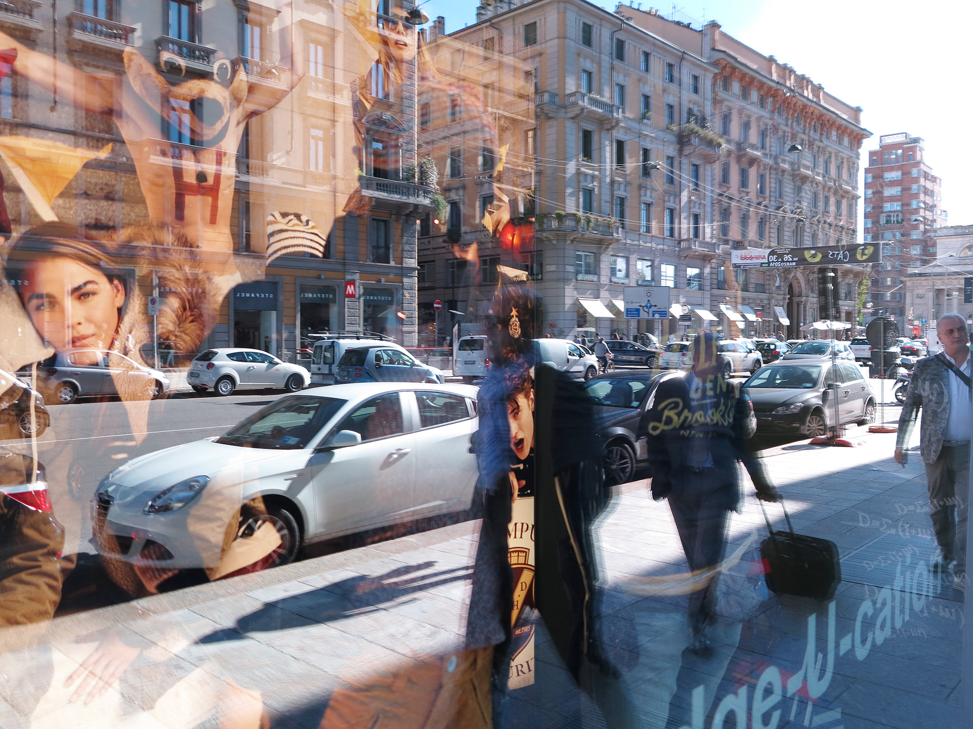 fotografia powstała w Mediolanie, jest odbicie ulicy miasta, z jej ruchem i dynamiką w witrynie sklepowej. Nakładające się obrazy tworzą nową rzeczywistość- fotomontarz..