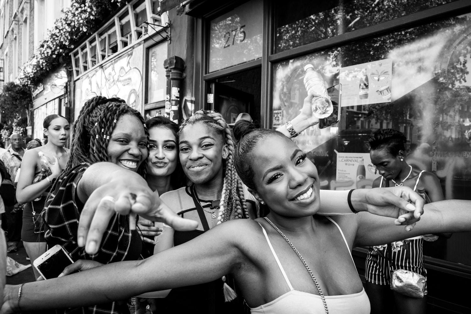 Four girls smiling together and pointing at the camera. Image © Nik van Herpt