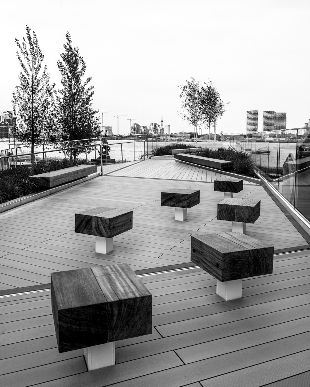 Wooden seats on The Tide walkway with the River Thames in the distance. Image © Nik van Herpt