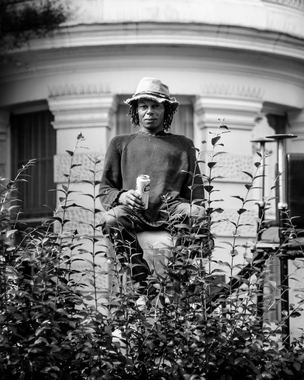 Man sitting high up in his garden drinking beer. Image © Nik van Herpt