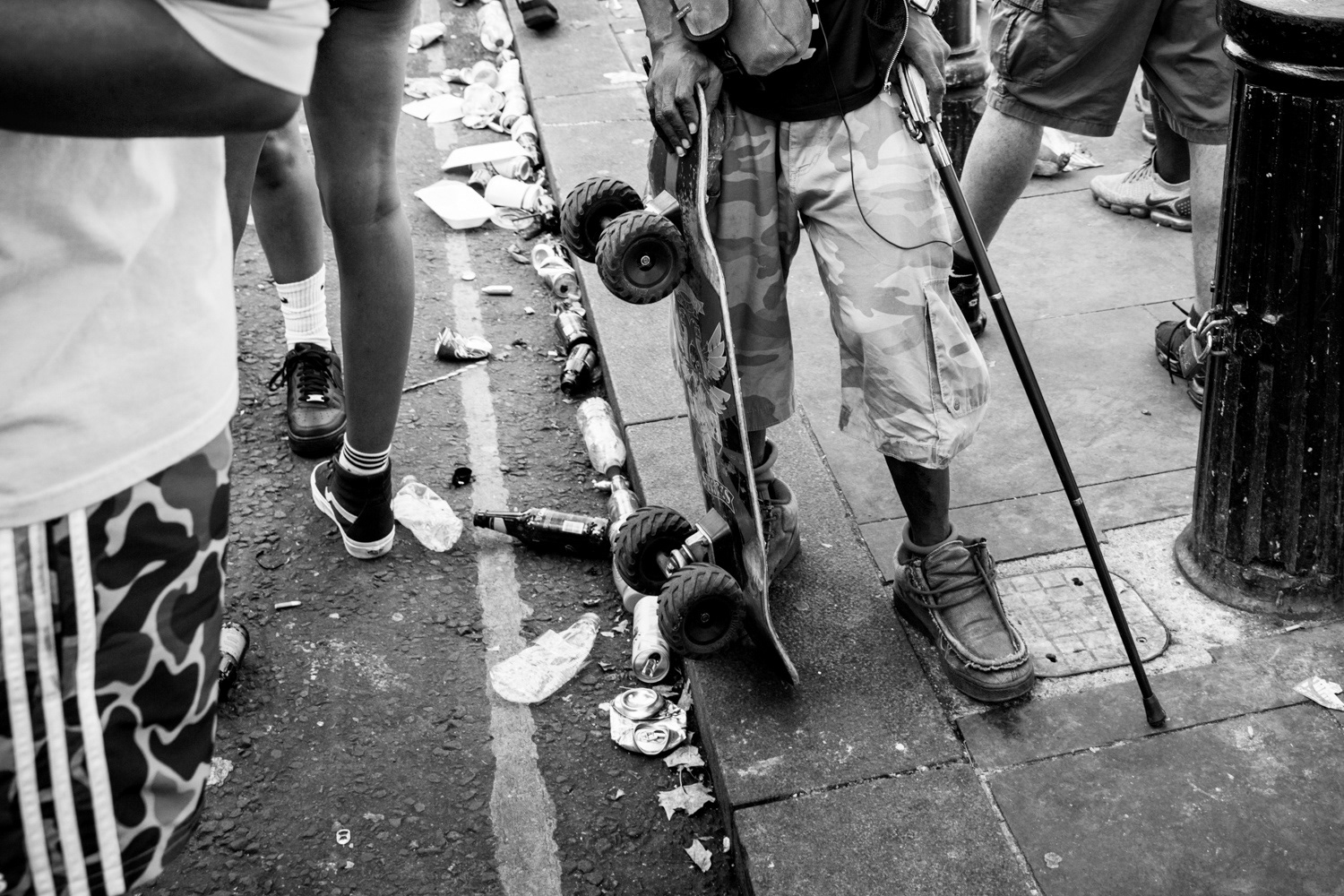 Man, with walking stick and skateboard with 4x4 wheels. Image © Nik van Herpt