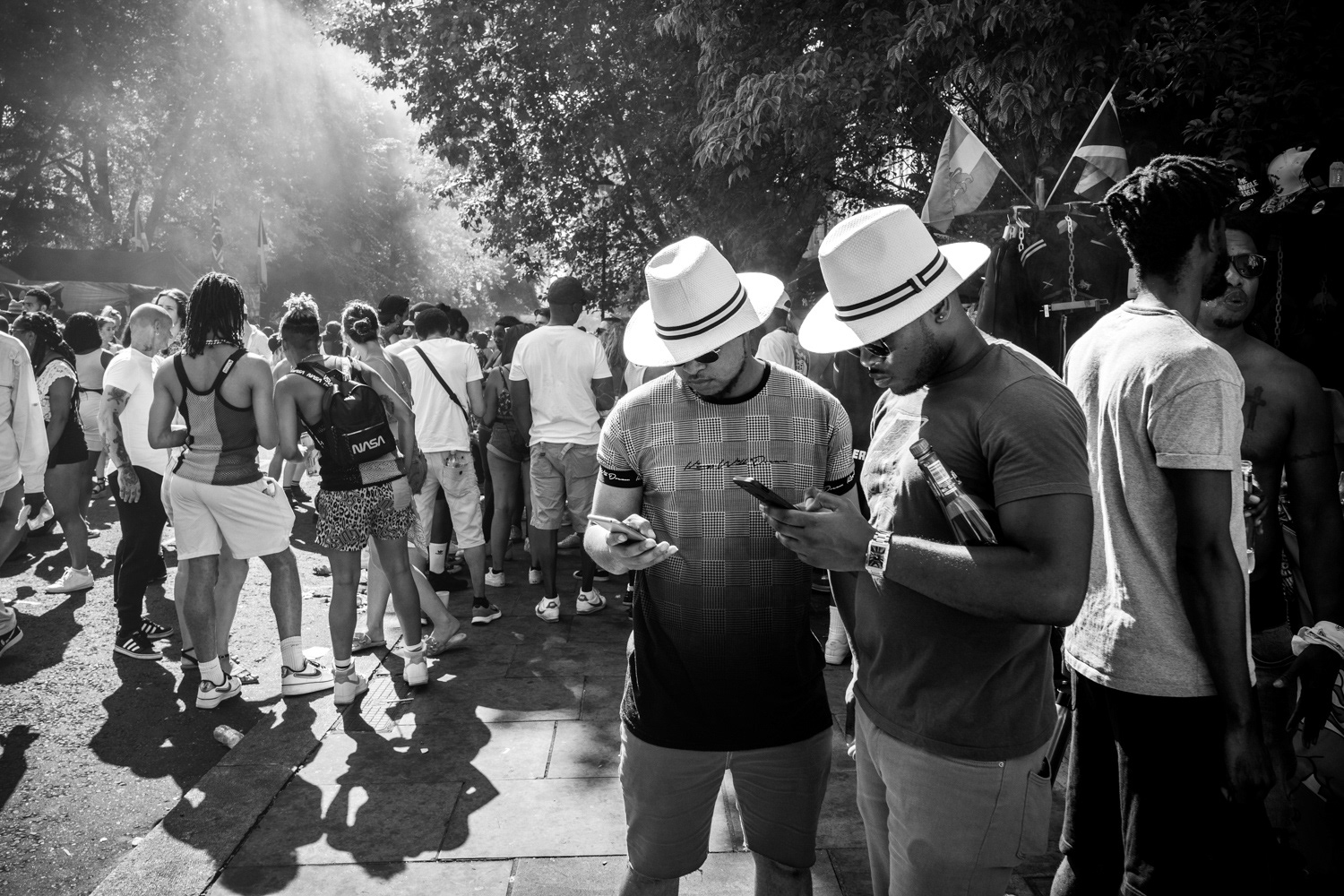 Two men in panama hats looking at mobile phones. Image © Nik van Herpt