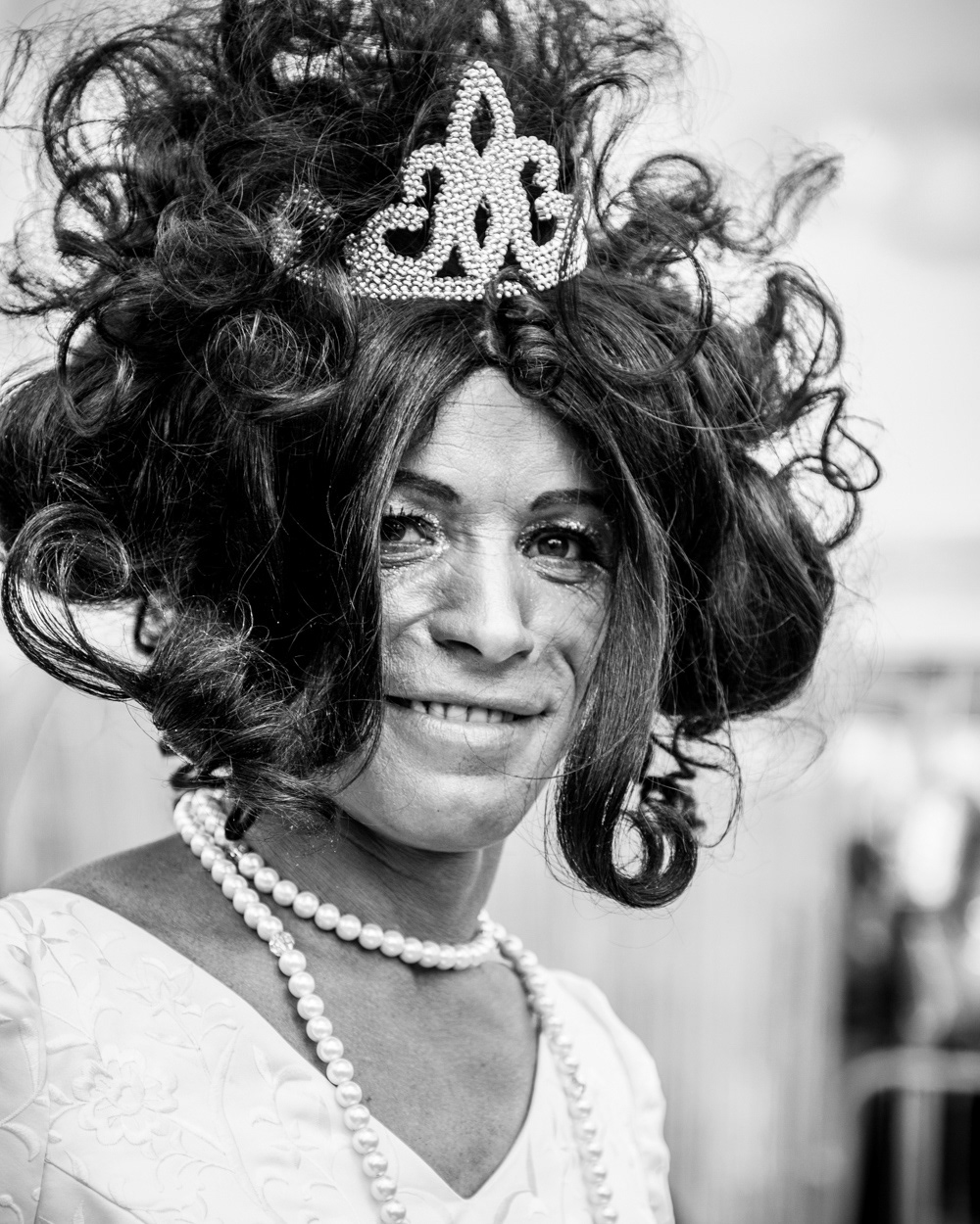 Man dressed as a woman with a wig, a crown and pearls. Image © Nik van Herpt