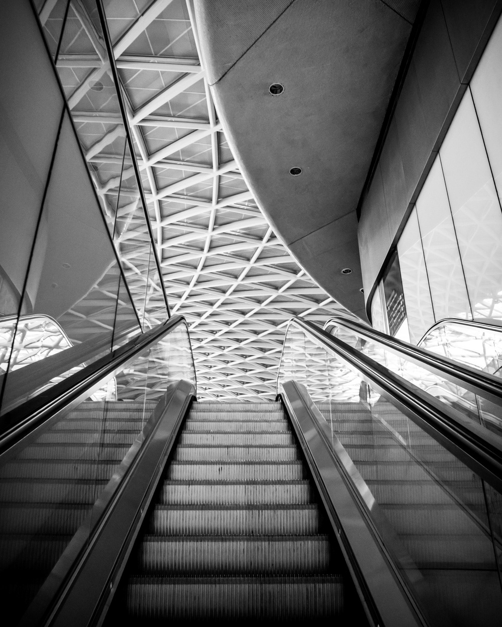 Escalator view of the semi-circular Western Concourse roof, Kings Cross Station. Image © Nik van Herpt