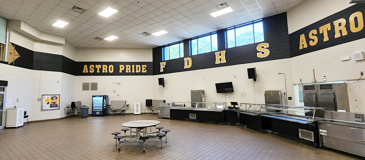 a full print adhesive banner black with yellow lettering with a white outline reading 'astro pride FDHS astro' and black a four point star outlined in white over a tan triangle and under yellow lettering with a white outline reading 'FD'